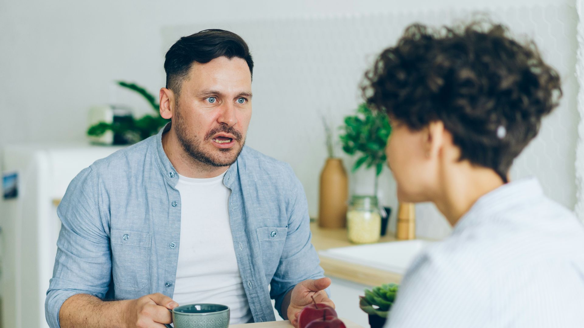 a man sitting at a table talking to a woman