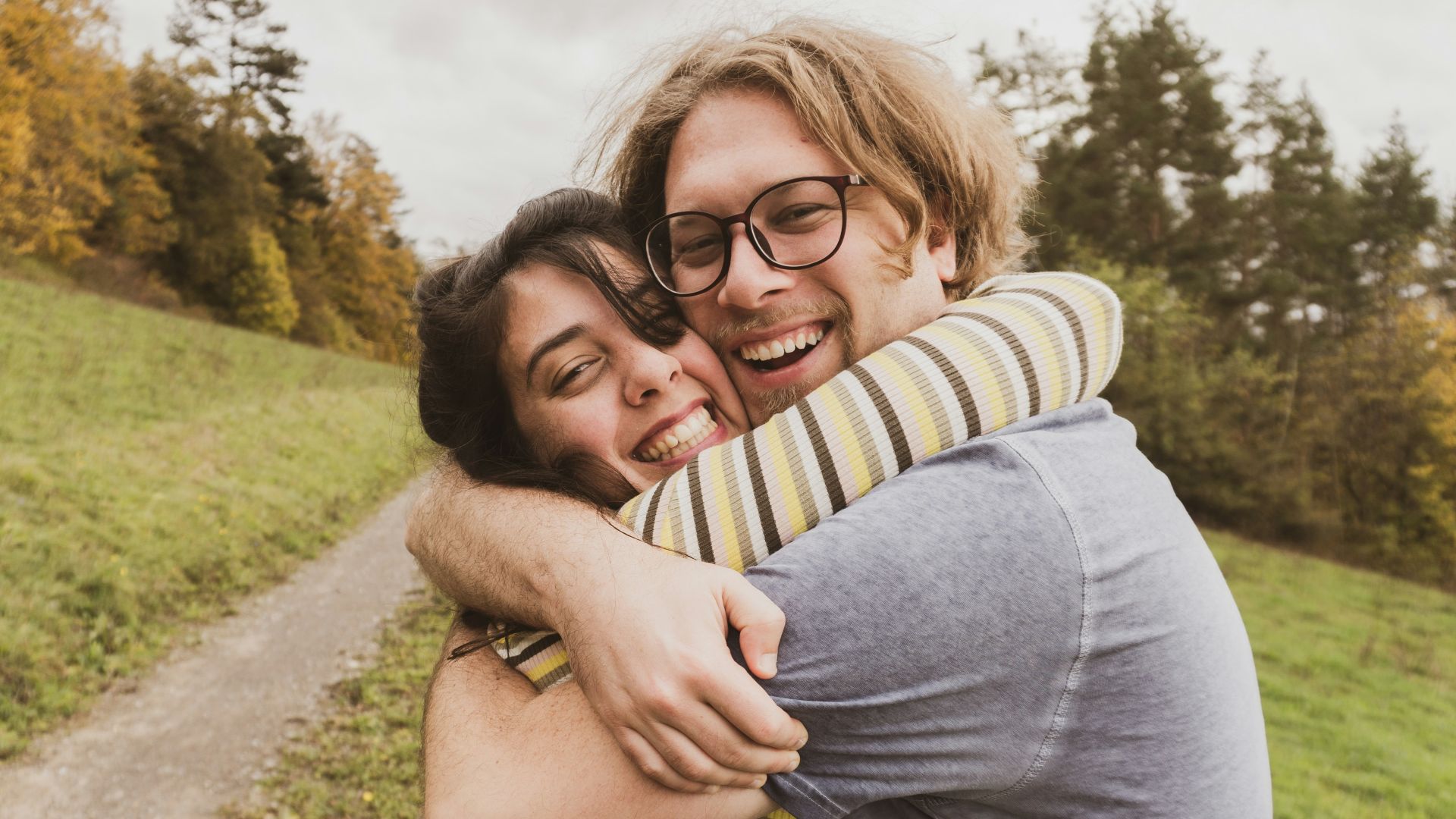 man and woman hugging near trees