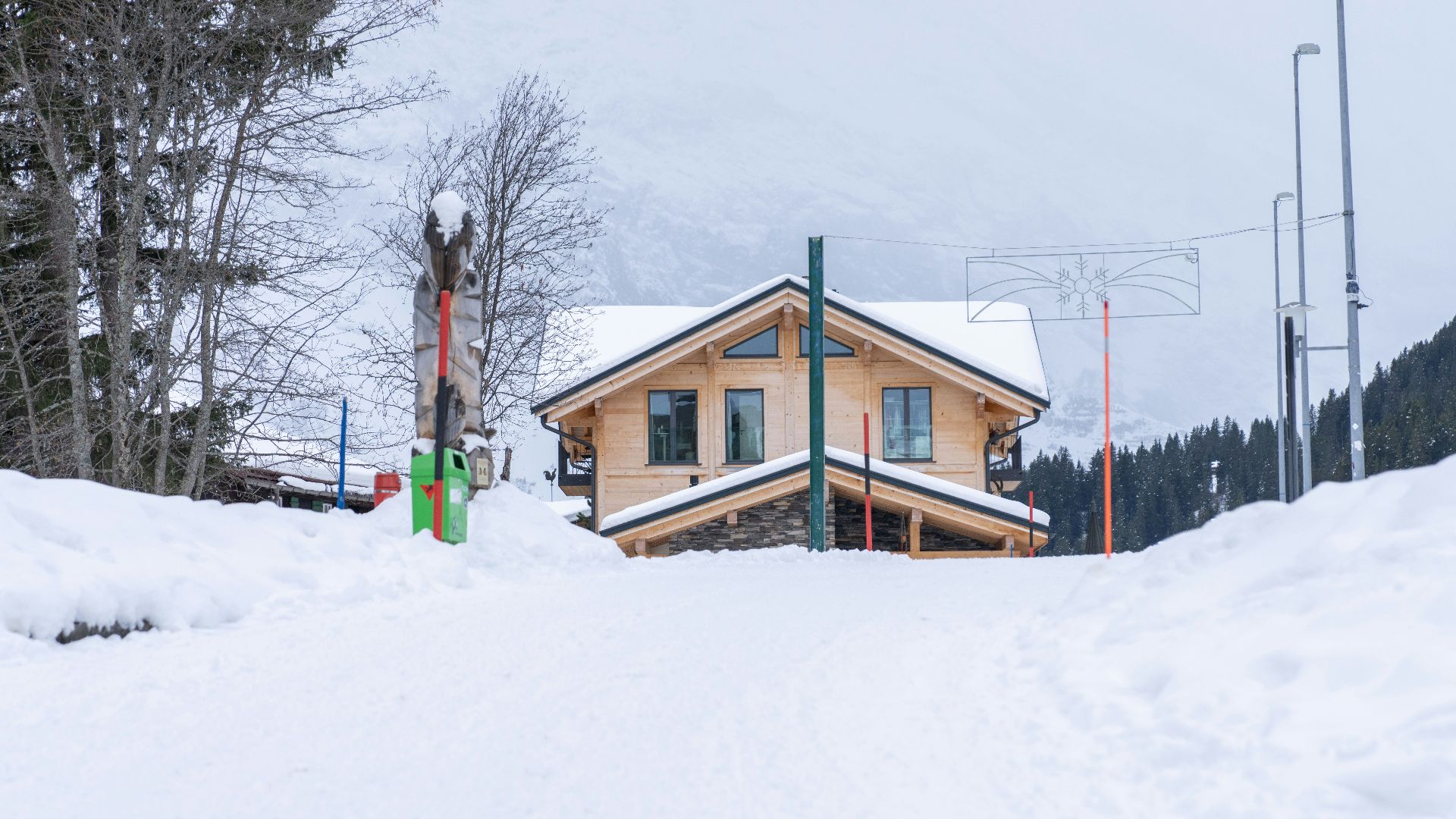 a snow covered ski slope with a house on top of it