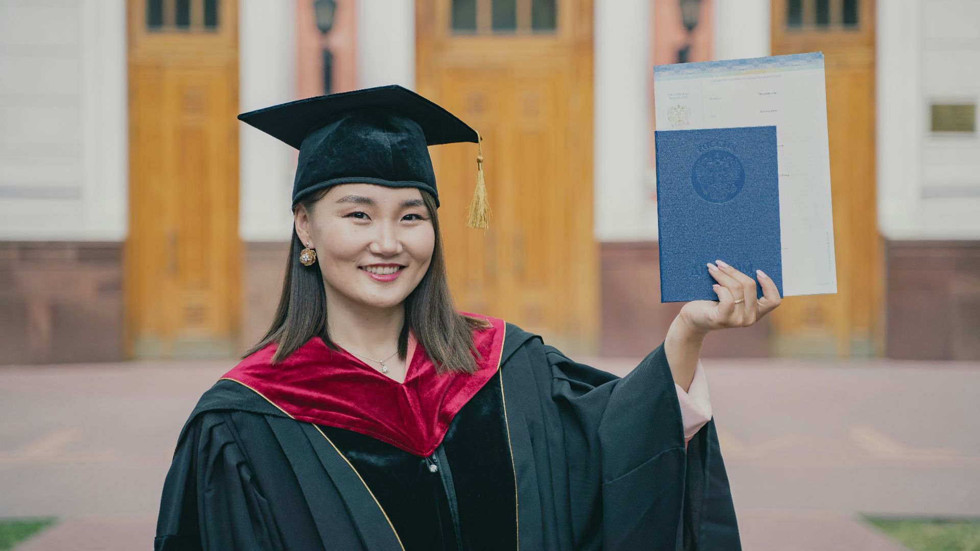 a woman in a graduation cap and gown holding a diploma