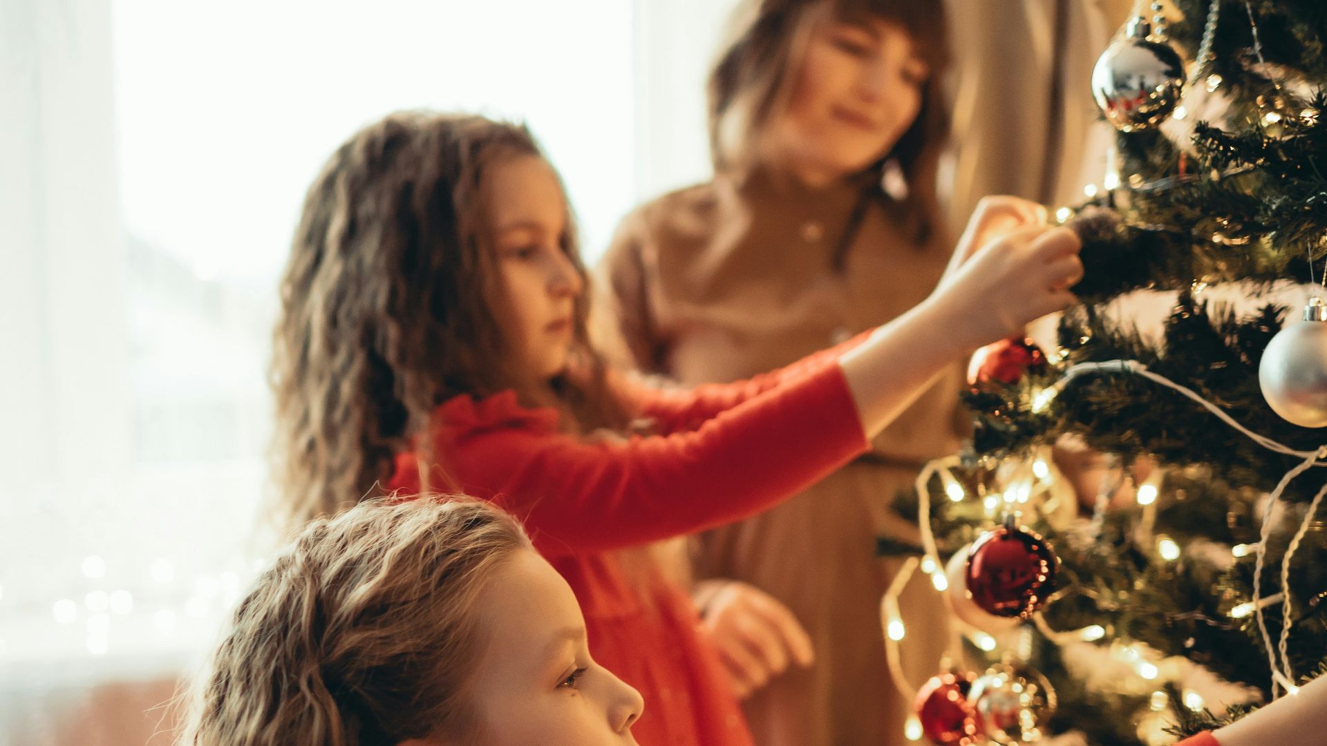 a group of young girls decorating a christmas tree