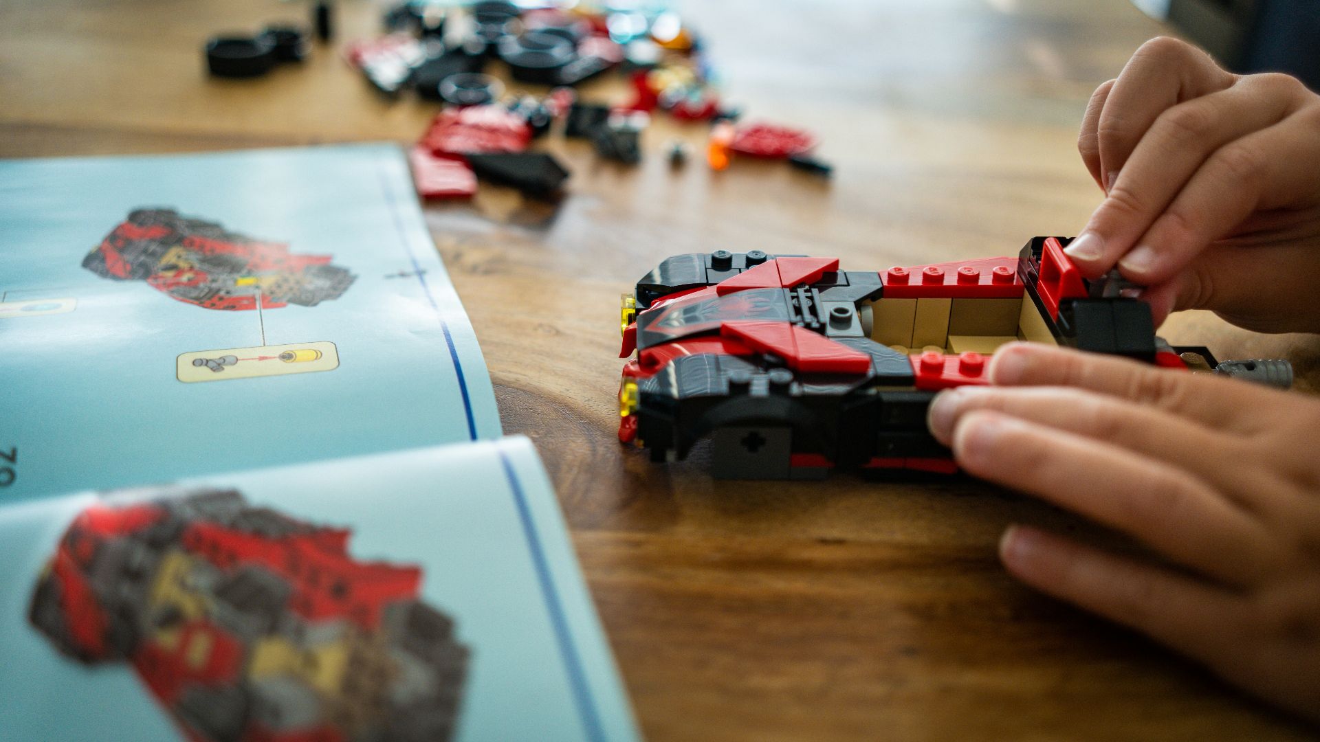 A person playing with a toy car on a table
