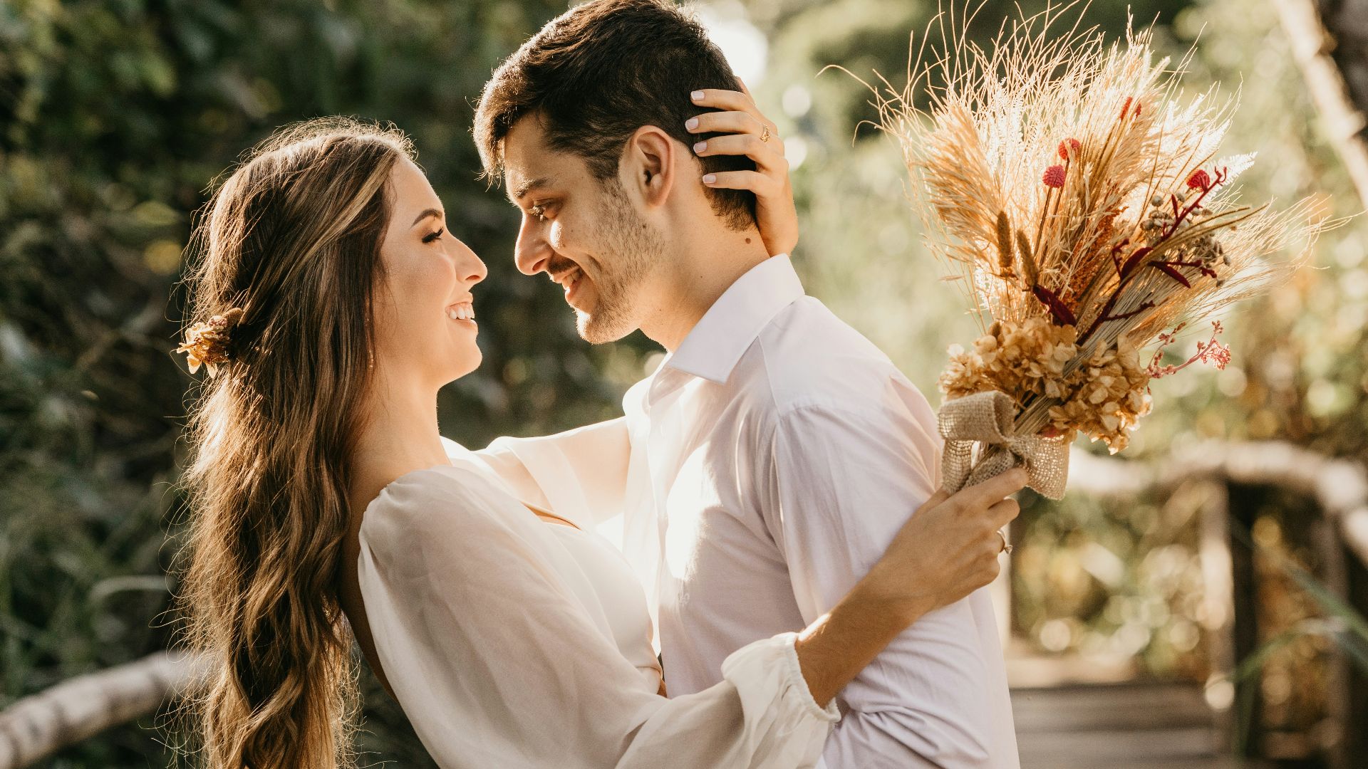 man in white dress shirt holding brown flower bouquet