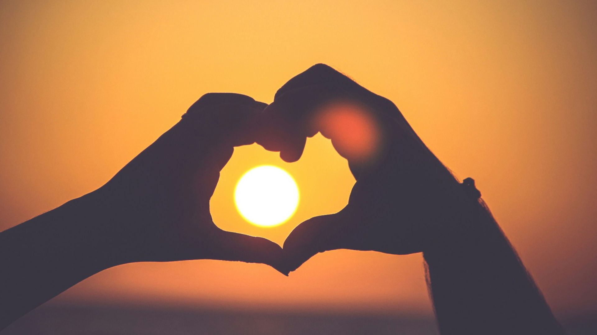 silhouette of person's hands forming heart