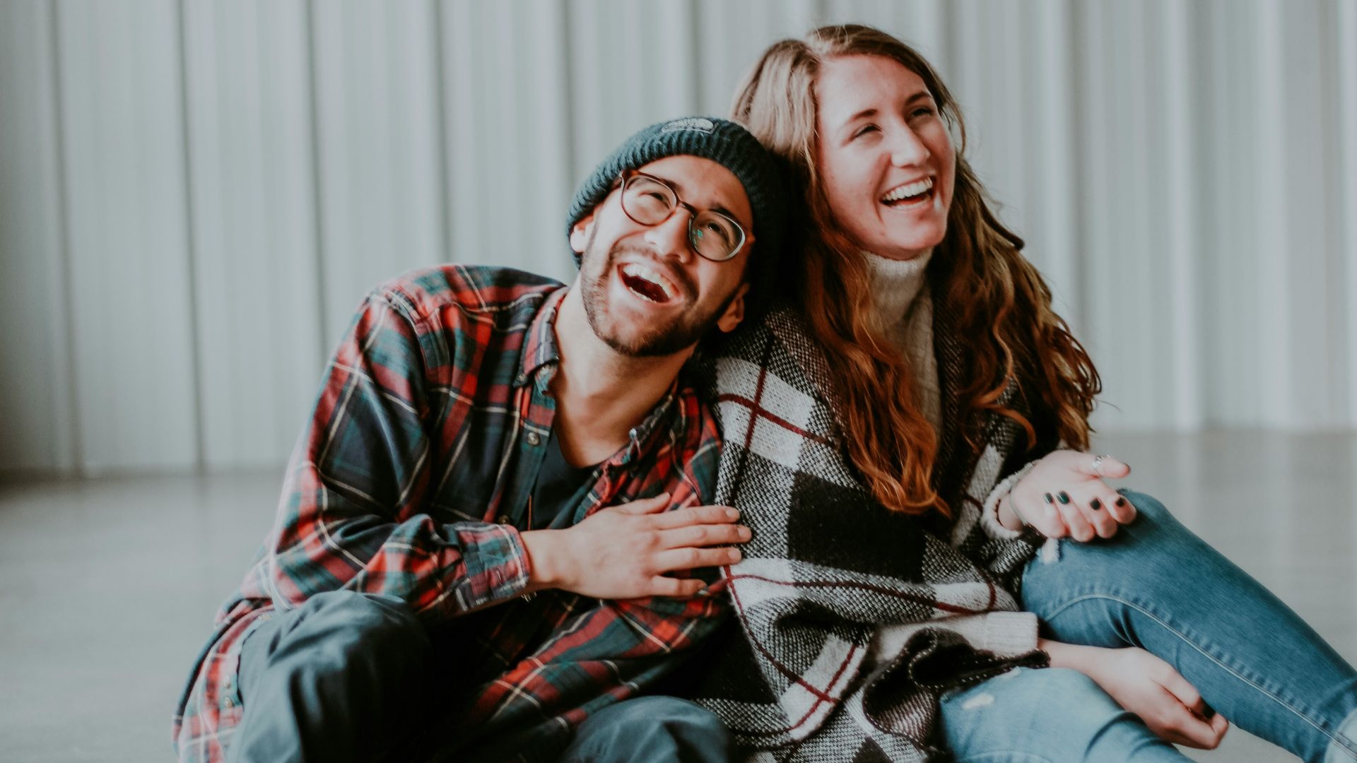 smiling woman and man sitting on floor
