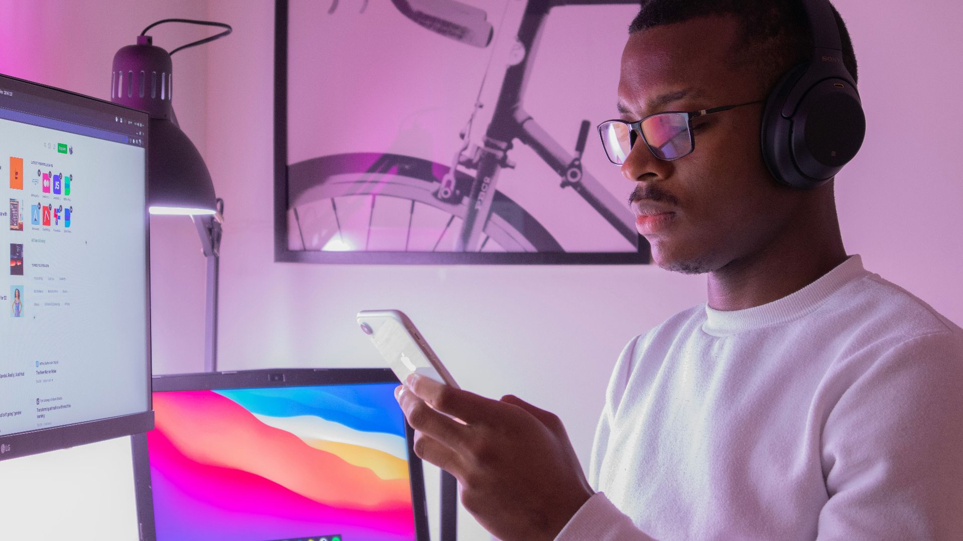 man in white crew neck shirt wearing black framed eyeglasses holding white tablet computer