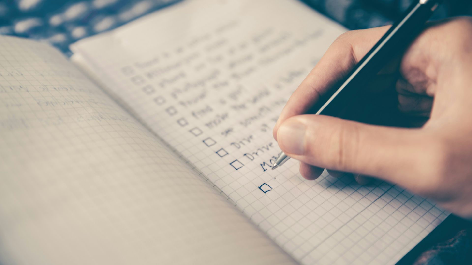 person writing bucket list on book