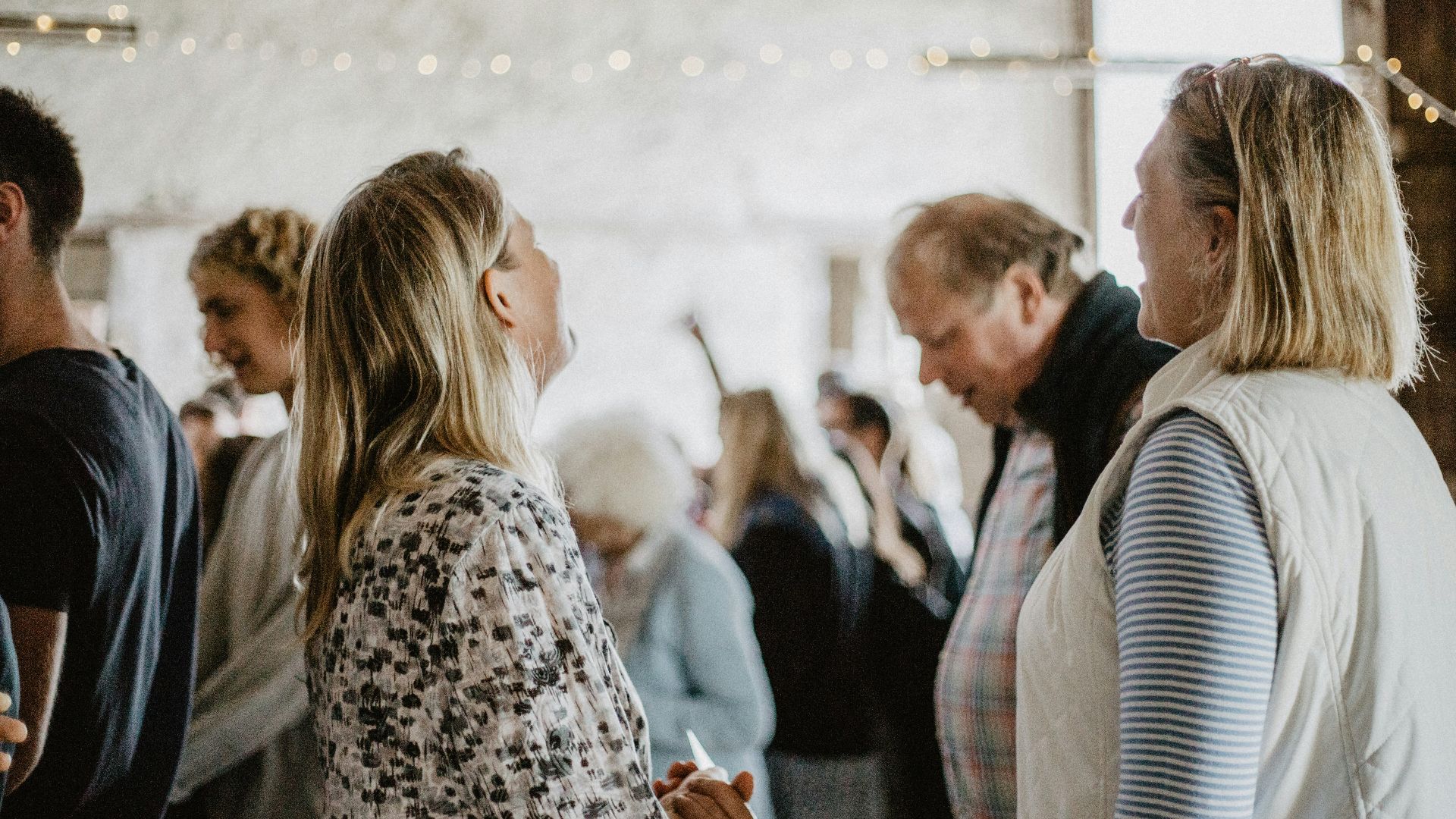 man in black suit jacket kissing woman in white and black leopard print coat