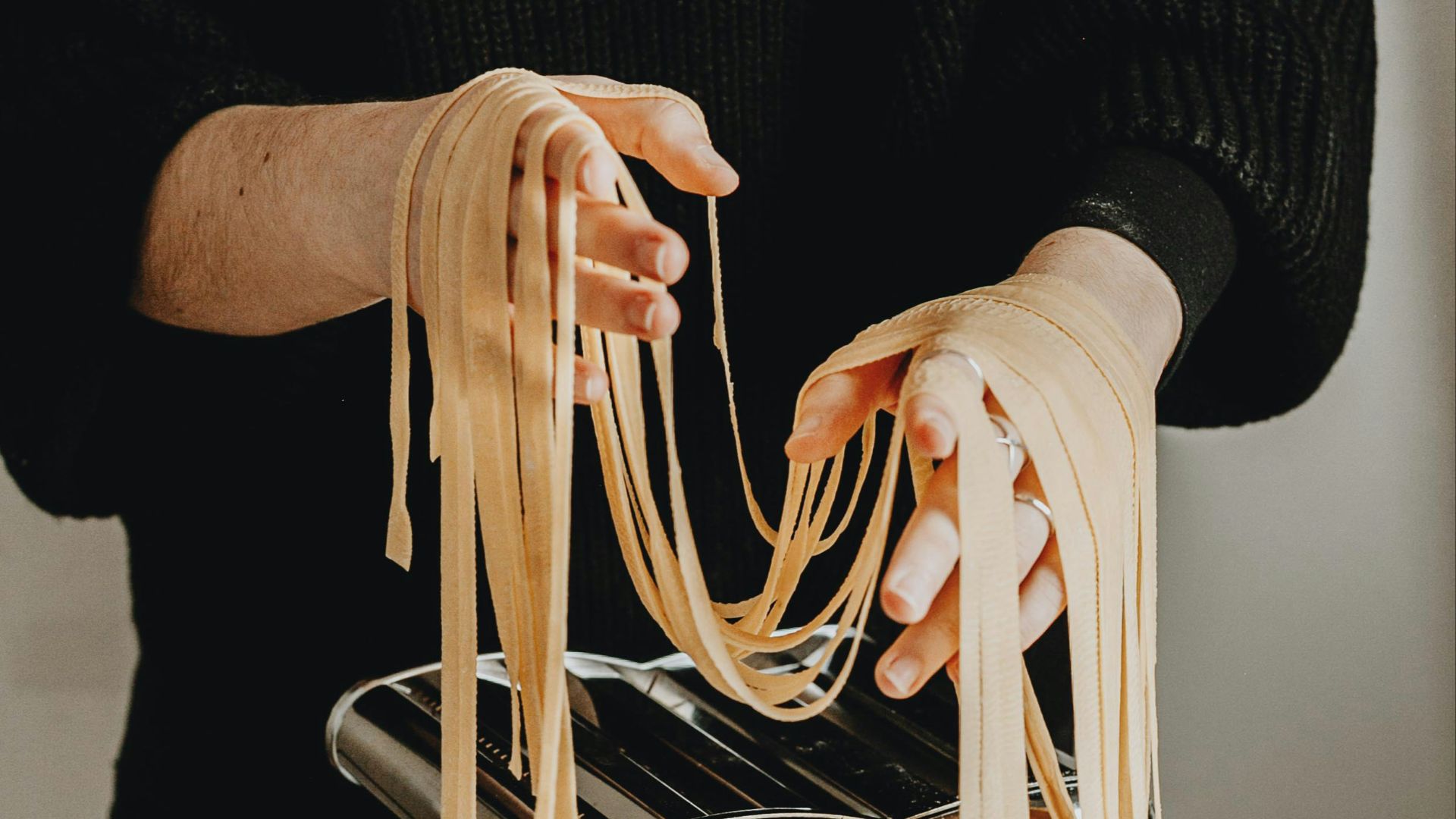 person in black sweater and black pants sitting on white chair