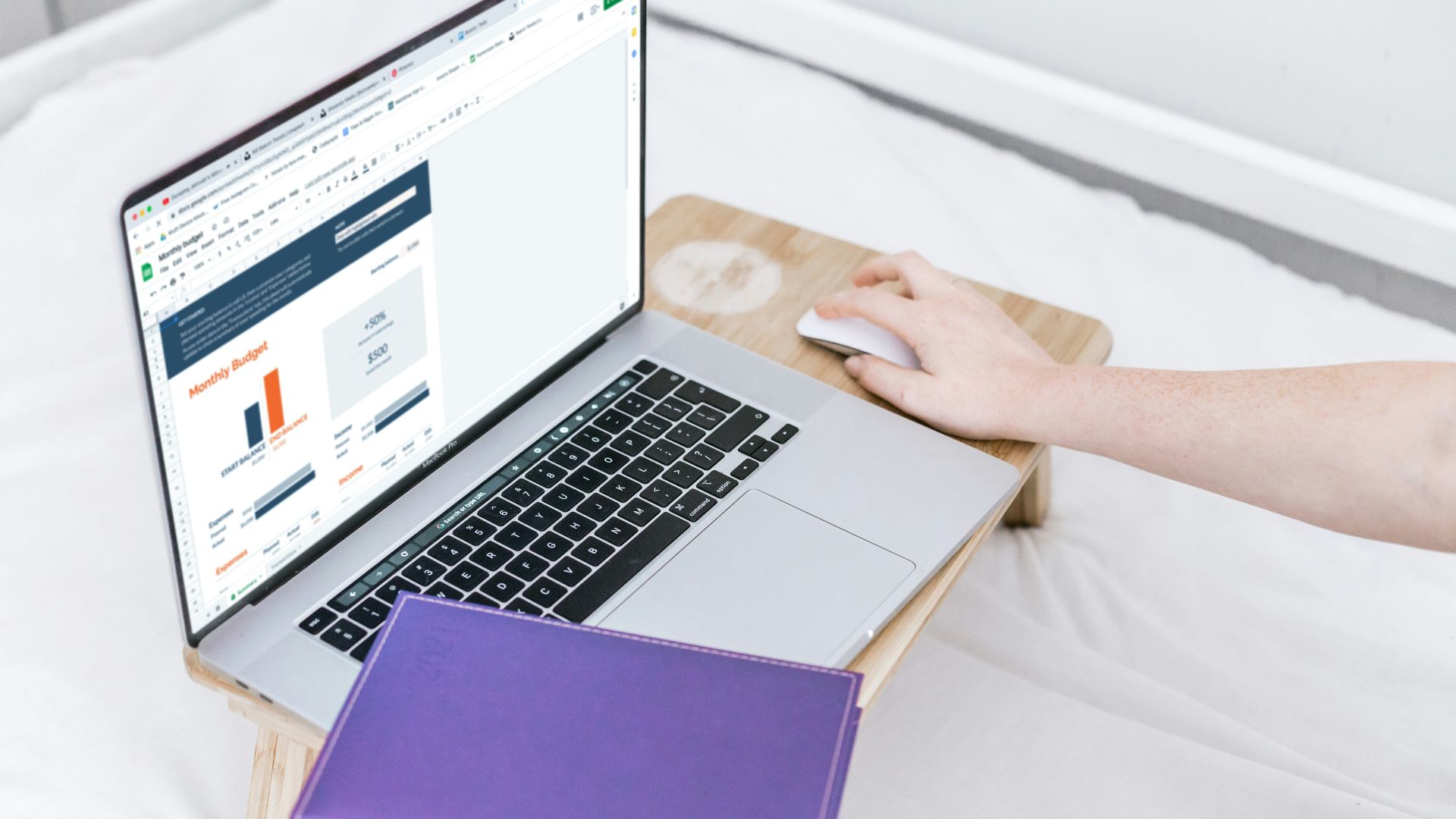 a person using a laptop computer on a bed