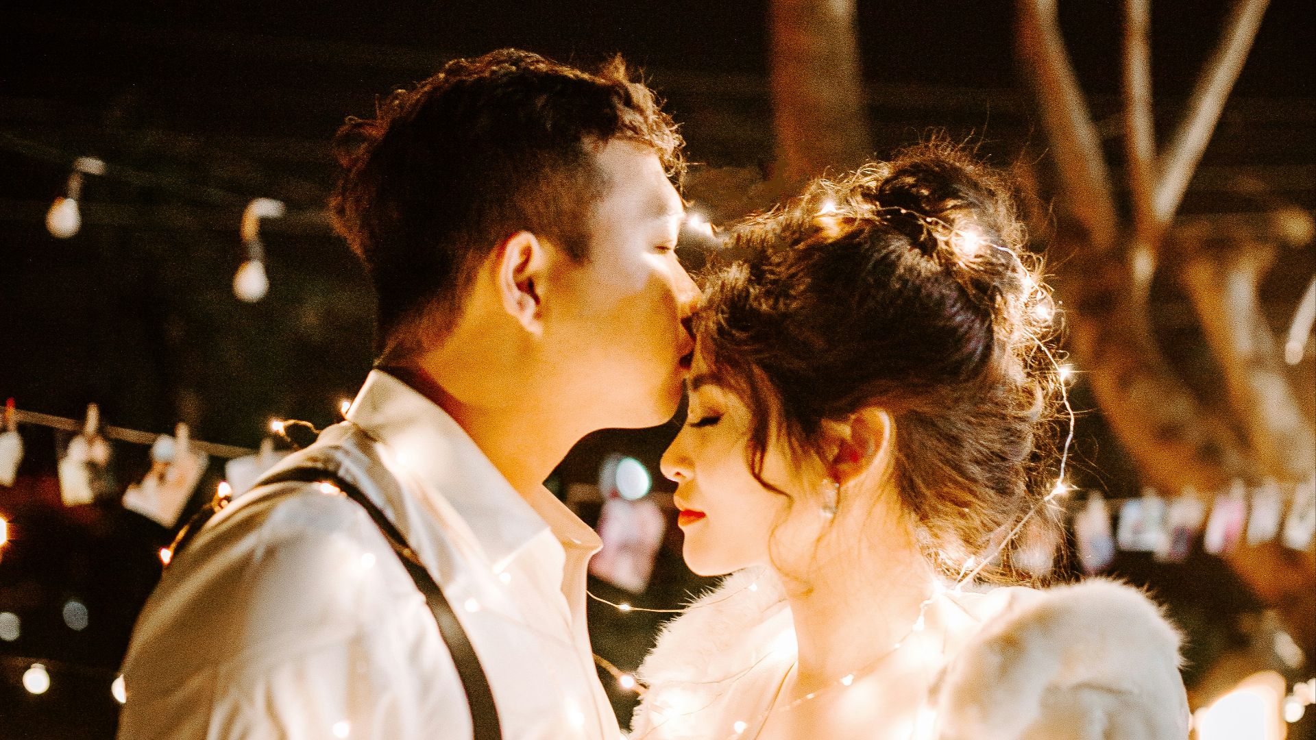 man kissing woman's forehead