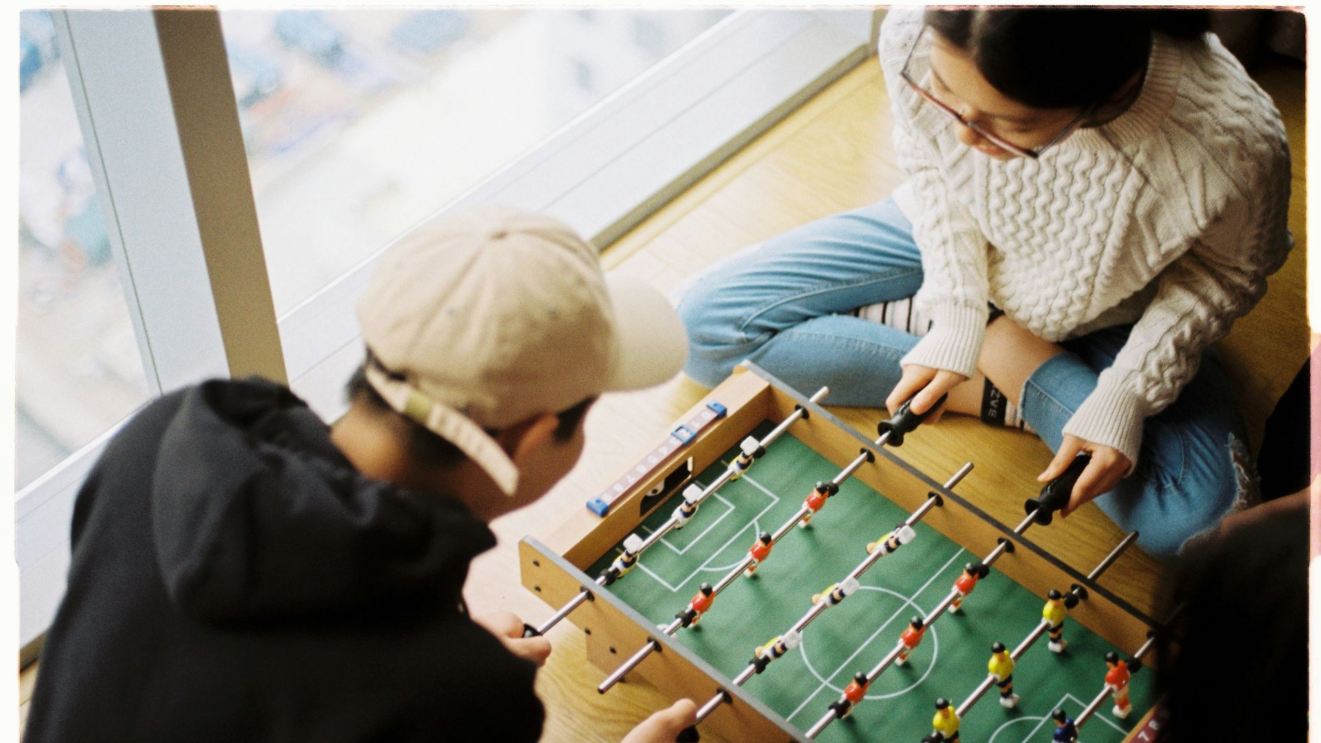 man and woman playing foosball table