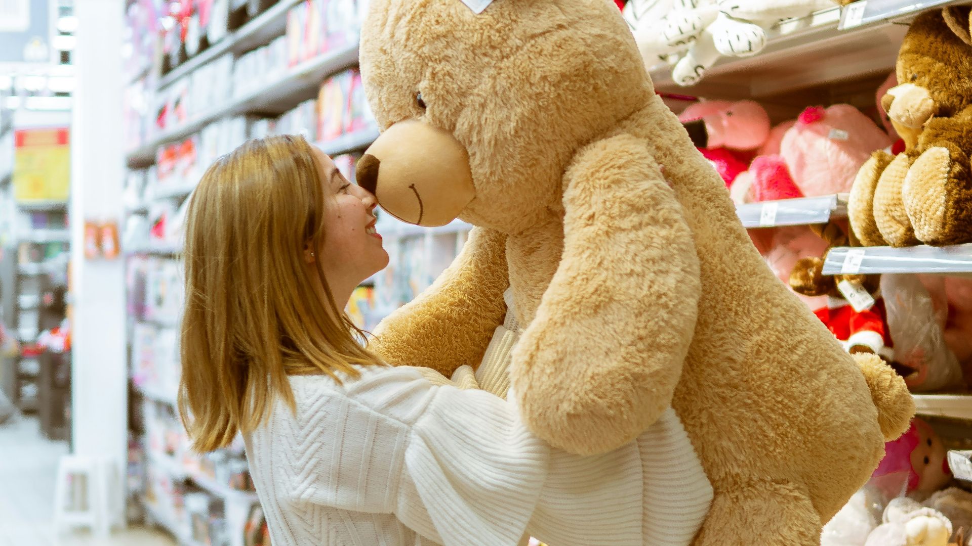 woman carrying life size bear plush toy
