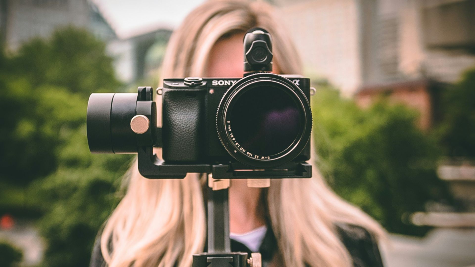 selective focus photography of woman holding camera gimbal