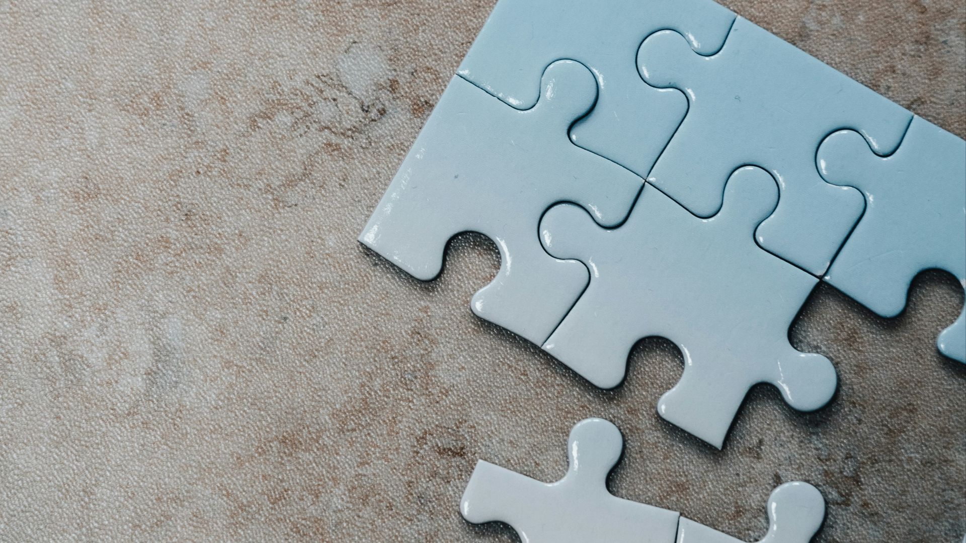 white jigsaw puzzle pieces on brown marble table