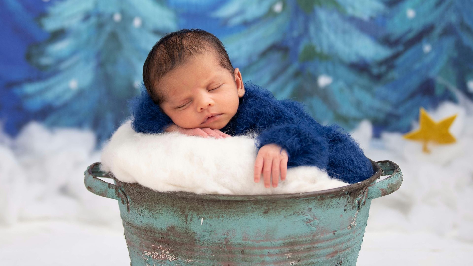 baby in white bucket on snow covered ground