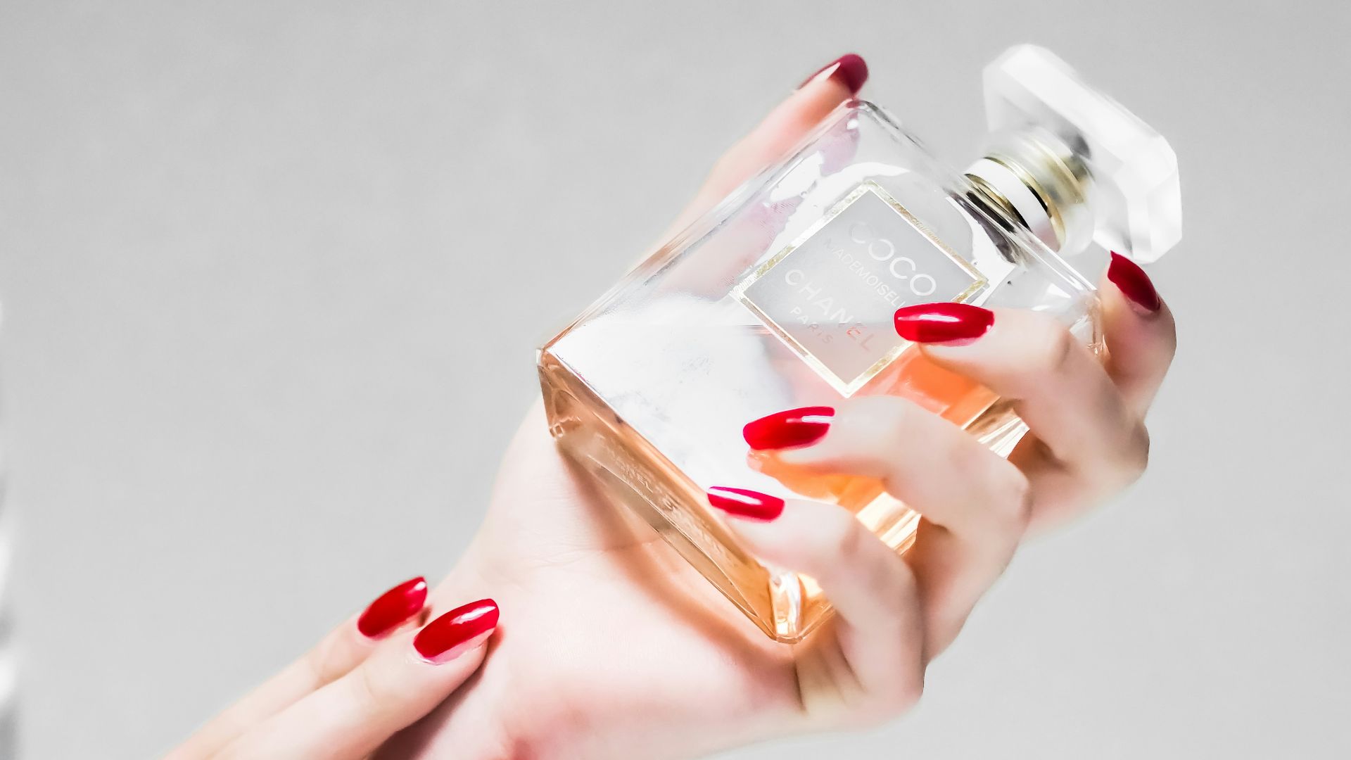 person holding clear glass bottle
