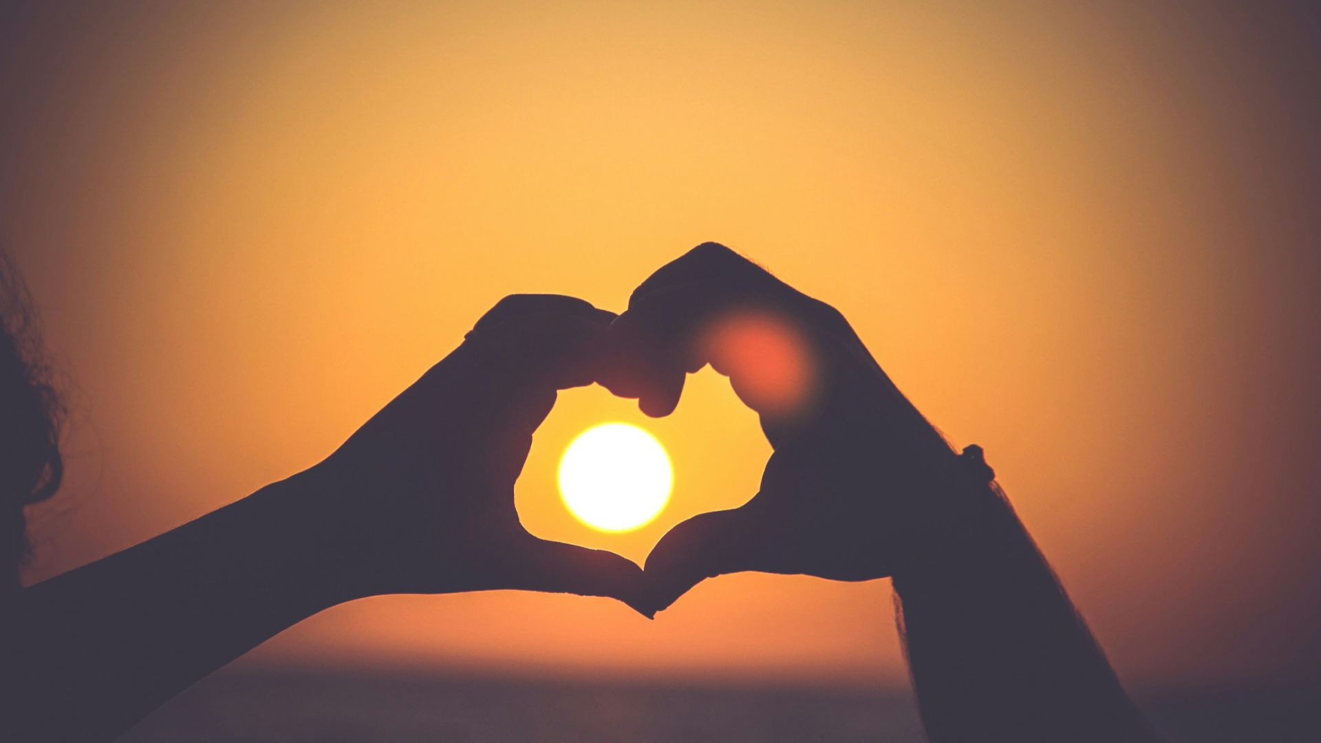 silhouette of person's hands forming heart