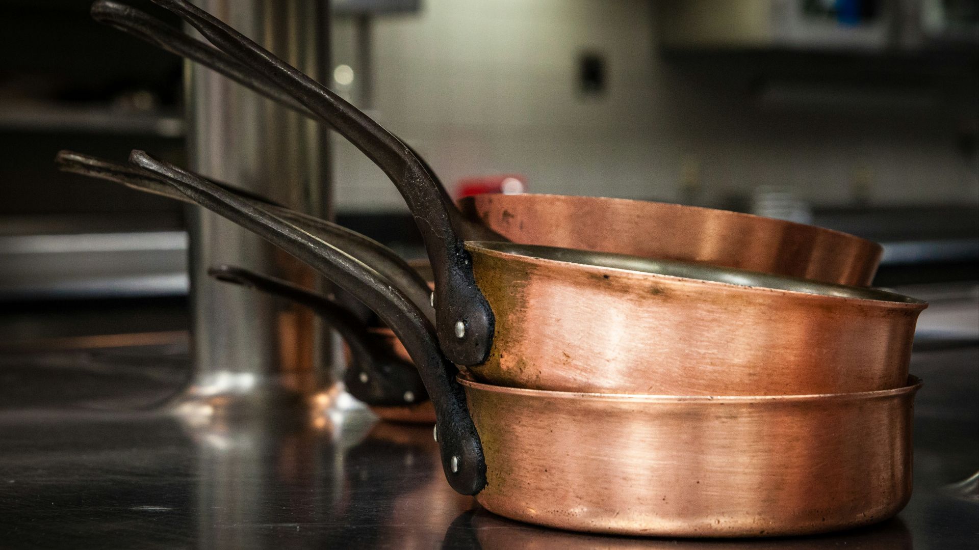 three brass colored cooking pans