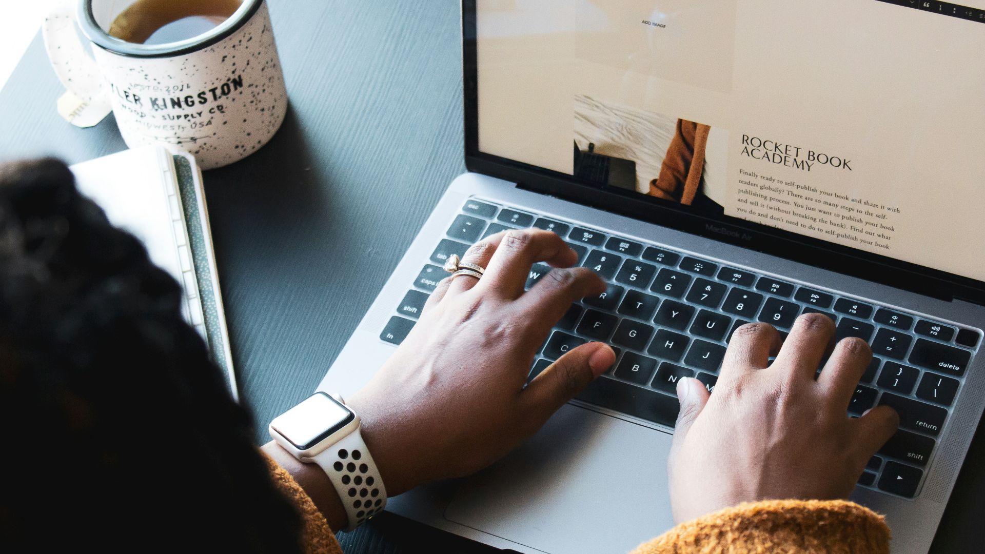 person using macbook pro on black table