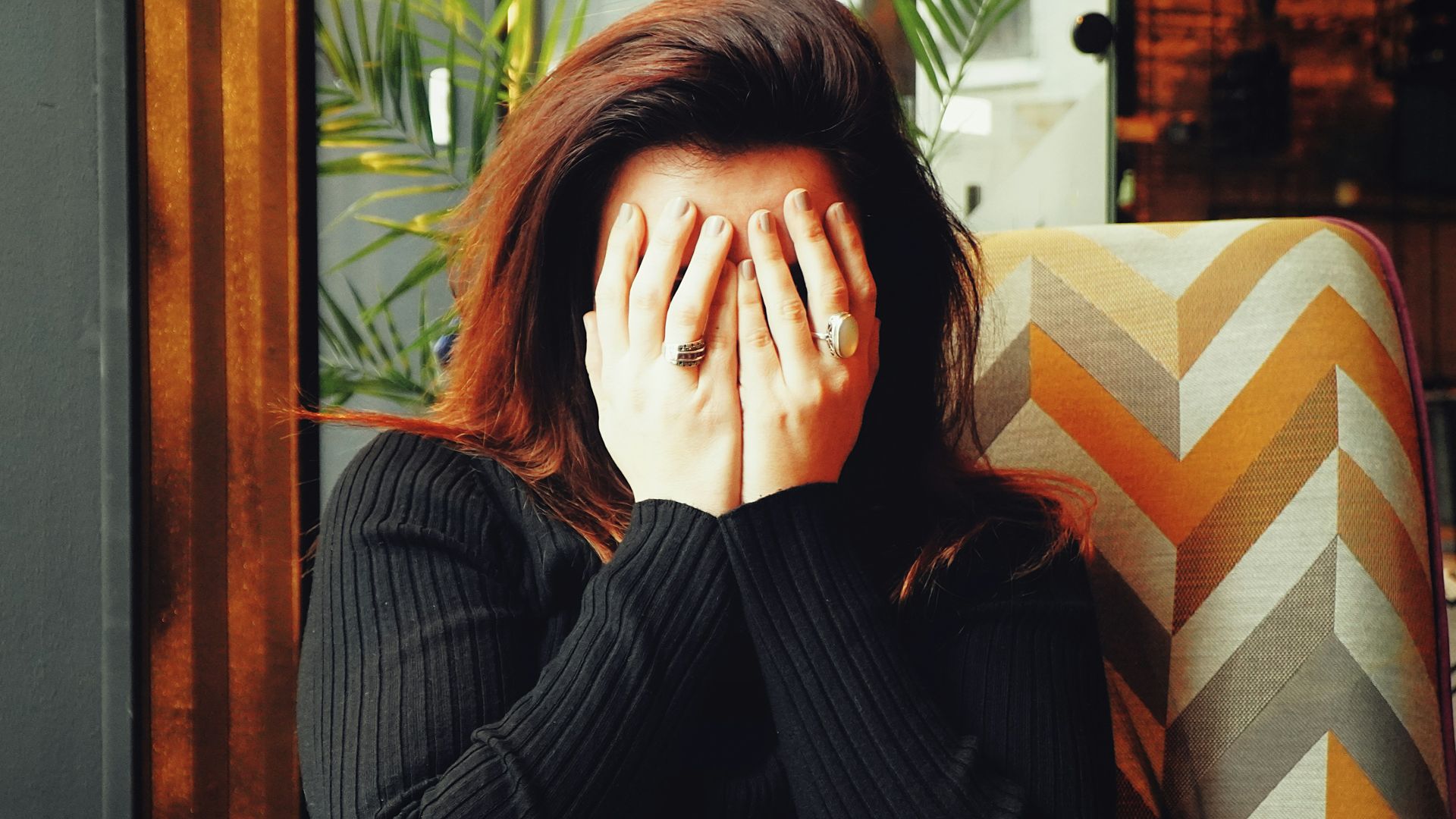 woman in black long sleeve shirt covering her face