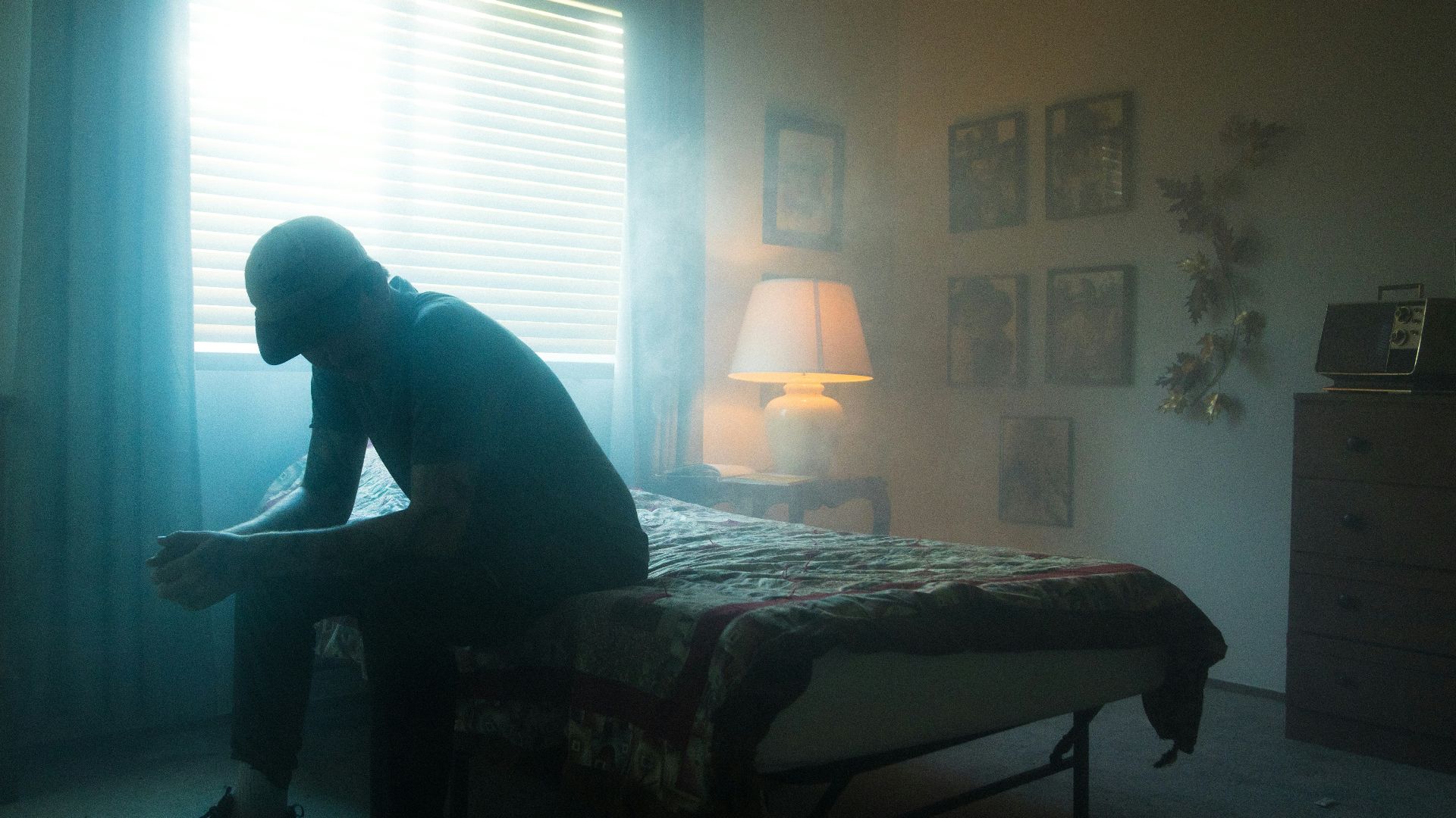 man in black jacket sitting on bed