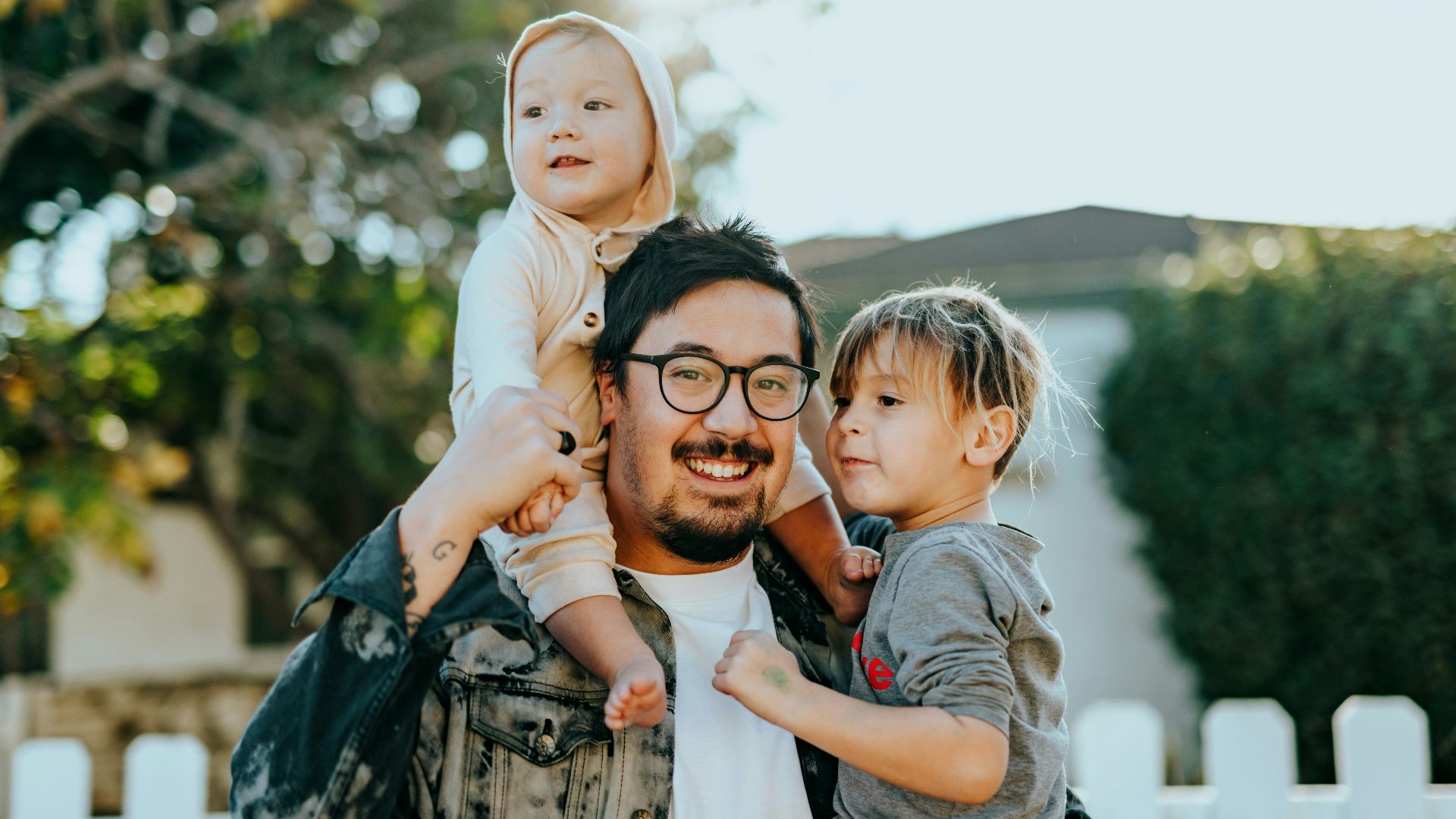 man in white shirt carrying girl in gray shirt