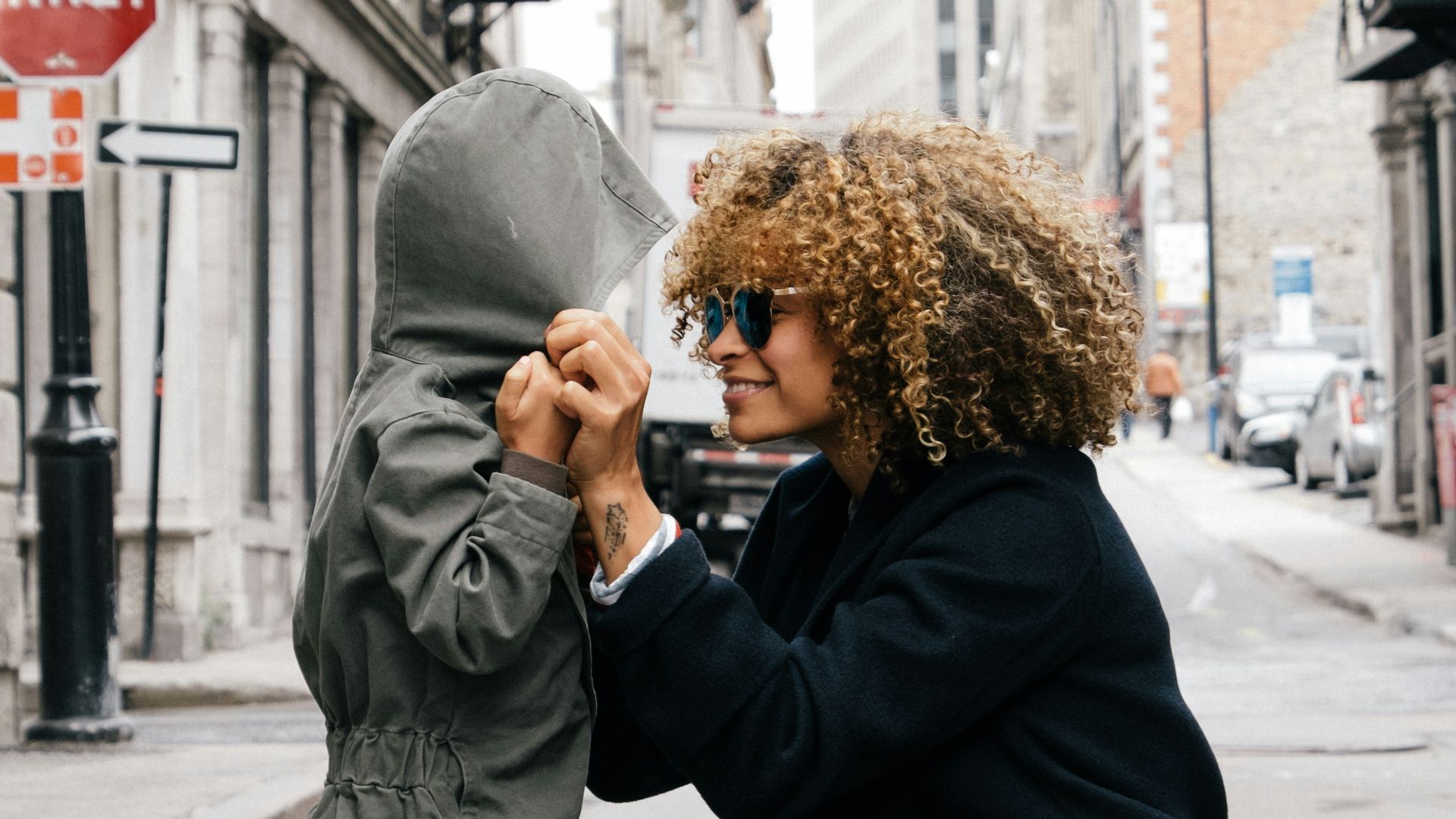 woman holding kid at the street