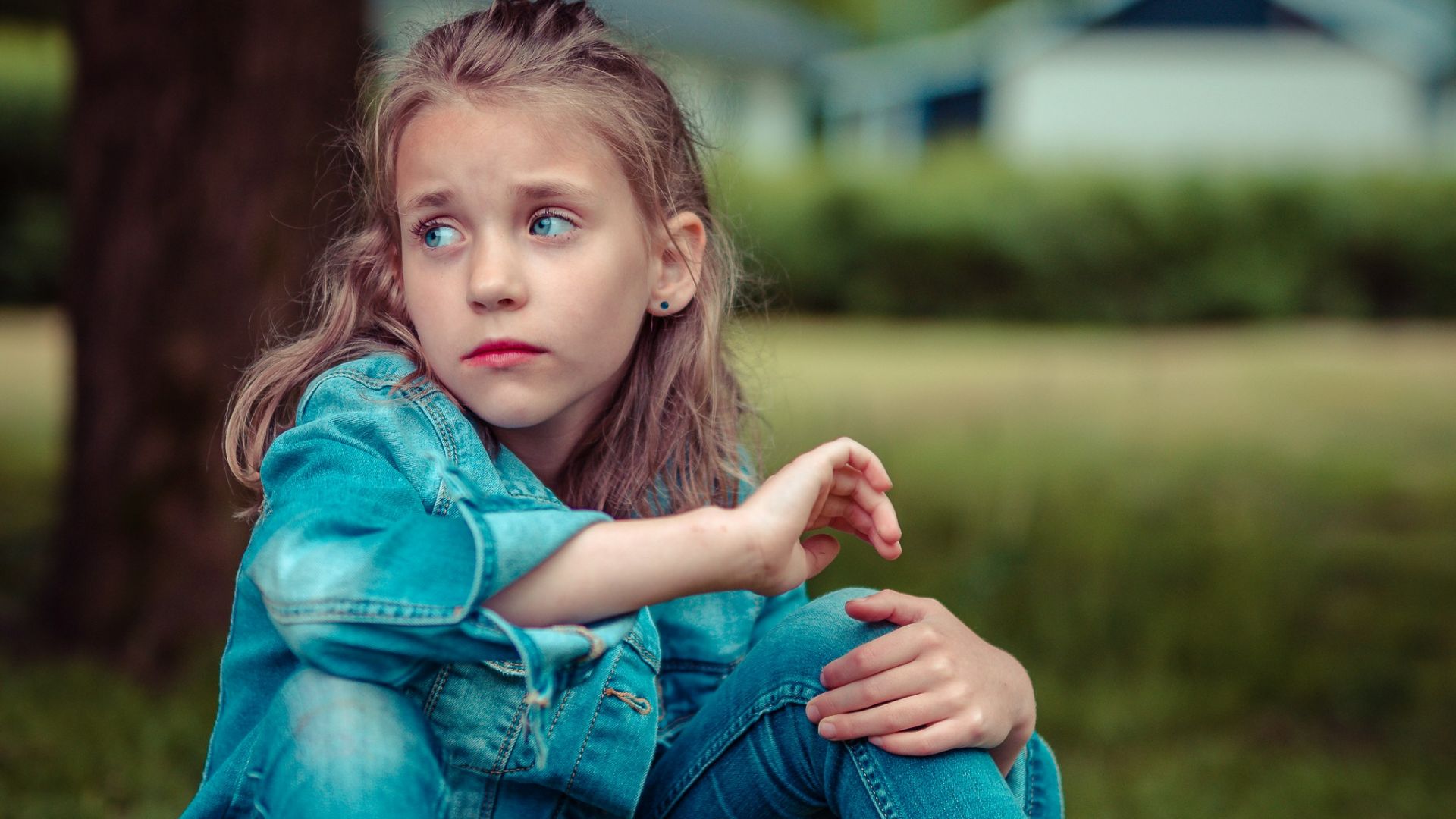 selective focus photography of girl sitting near tree