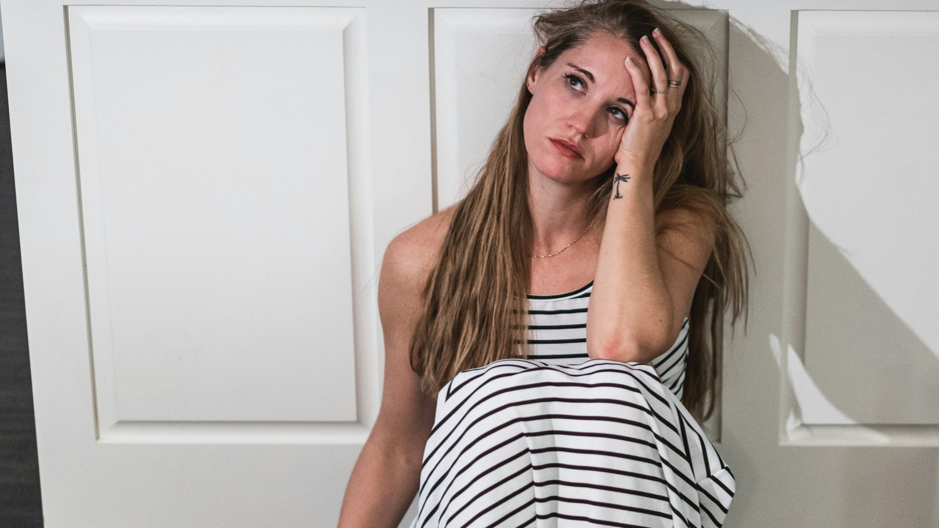 woman in black and white stripe dress holding wine glass