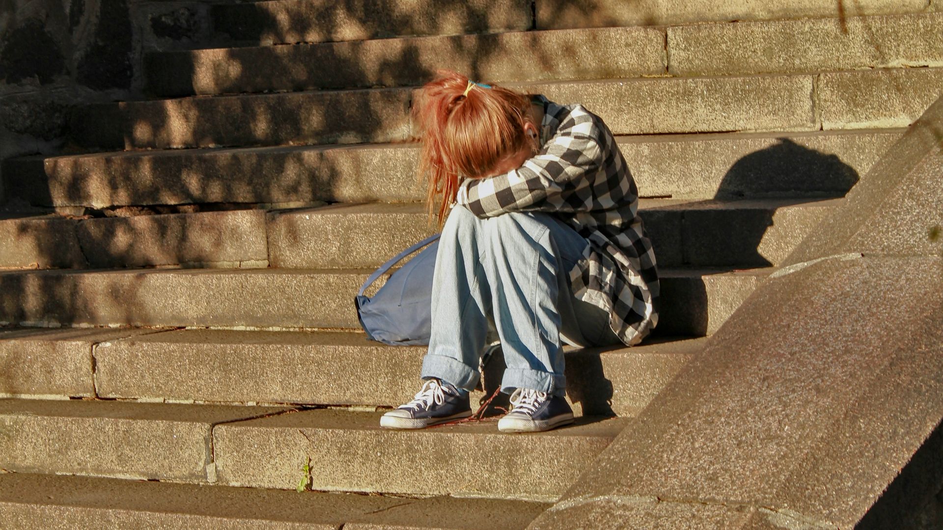 woman in black and white dress sitting on concrete stairs