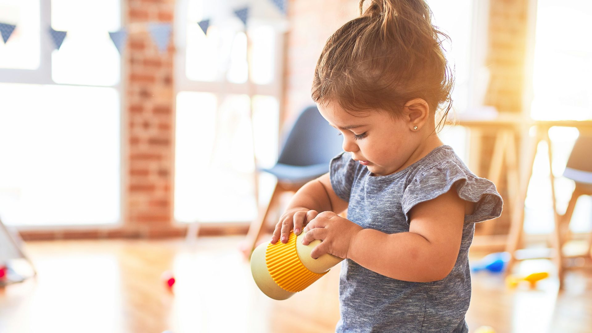 girl in blue denim dungaree pants holding blue and white polka dot handbag