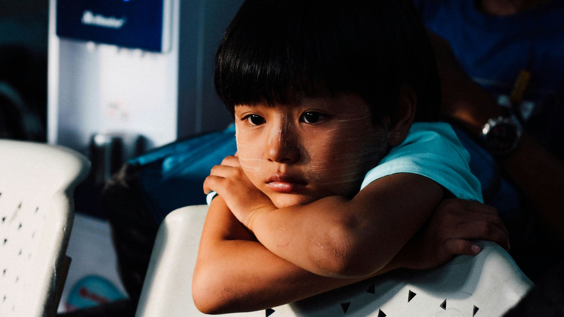 boy leaning on white chair
