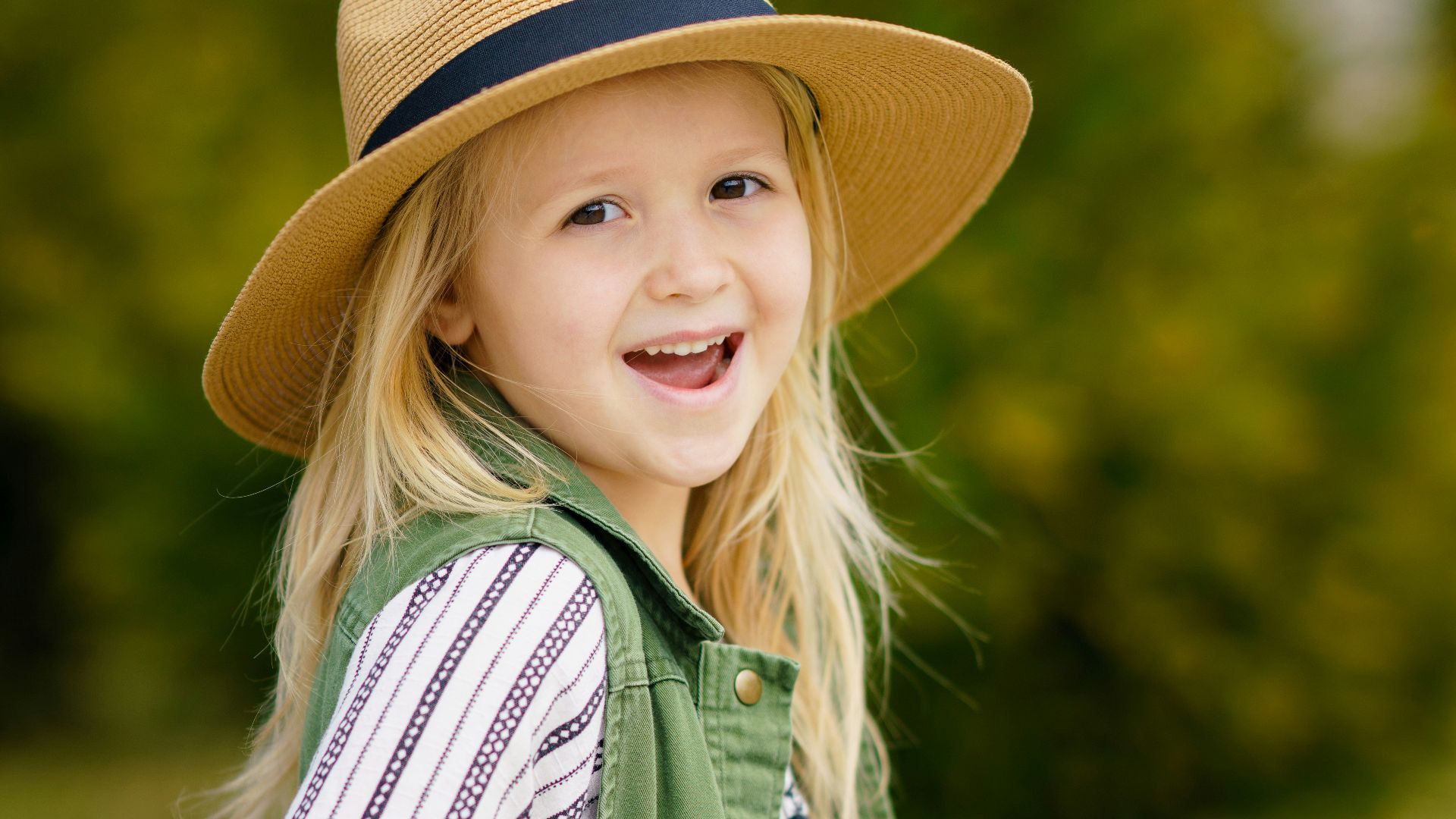 selective focus photography of girl smiling wearing sun hat