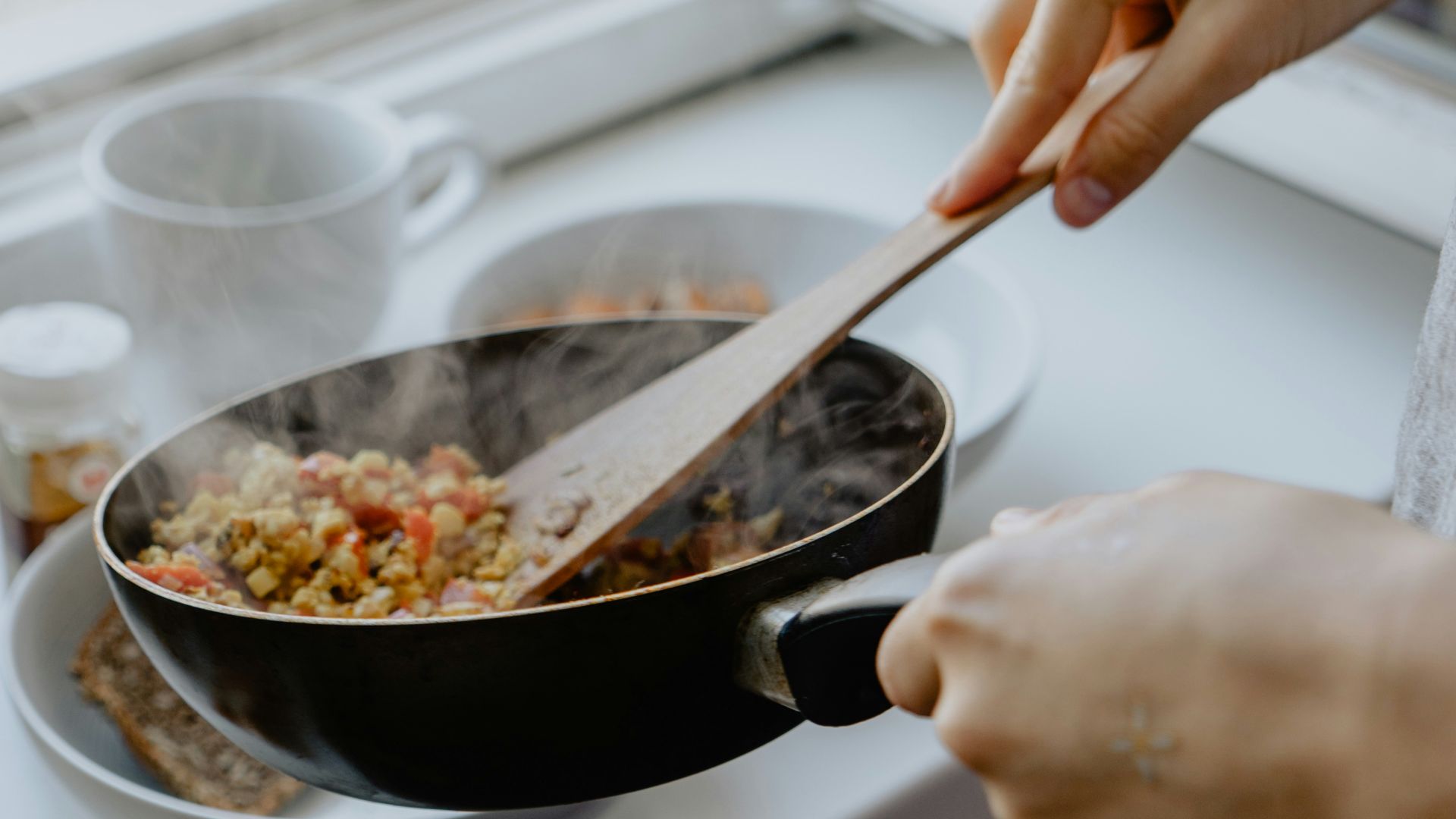 person holding black frying pan