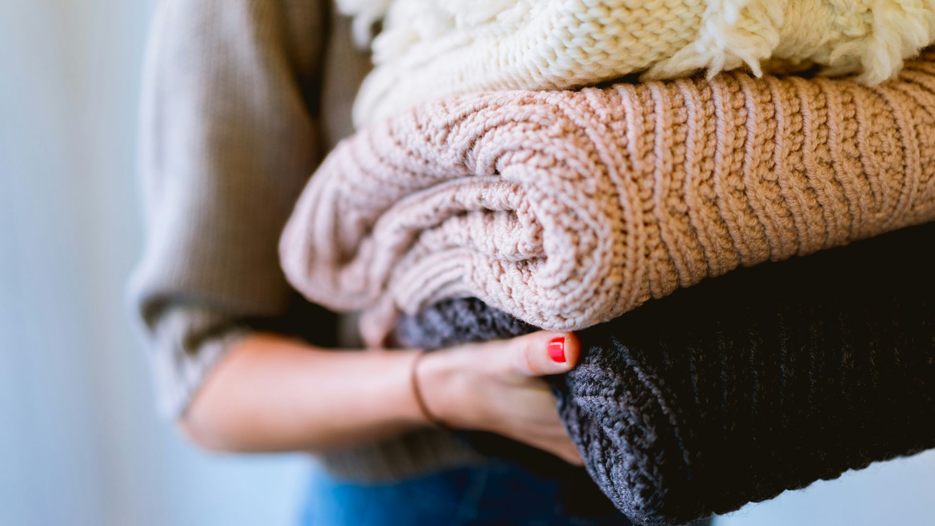 person holding knitted textiles