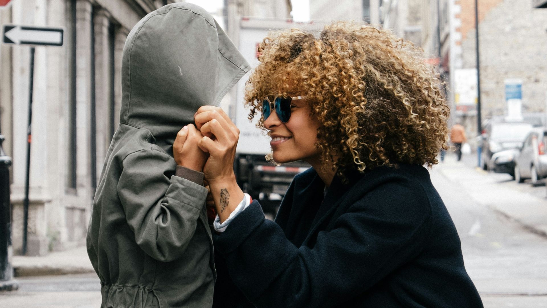 woman holding kid at the street
