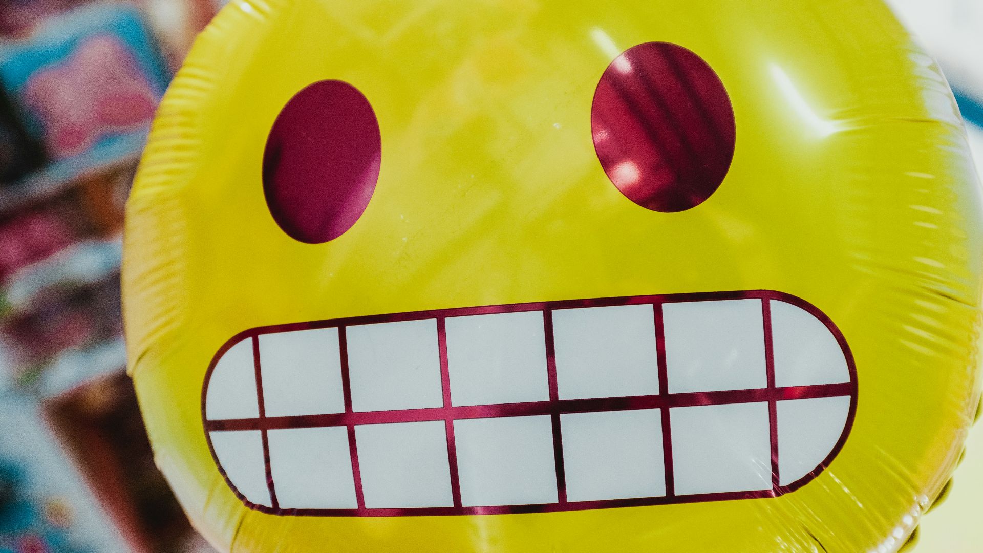 yellow inflatable smiling emoji balloon in focus photography