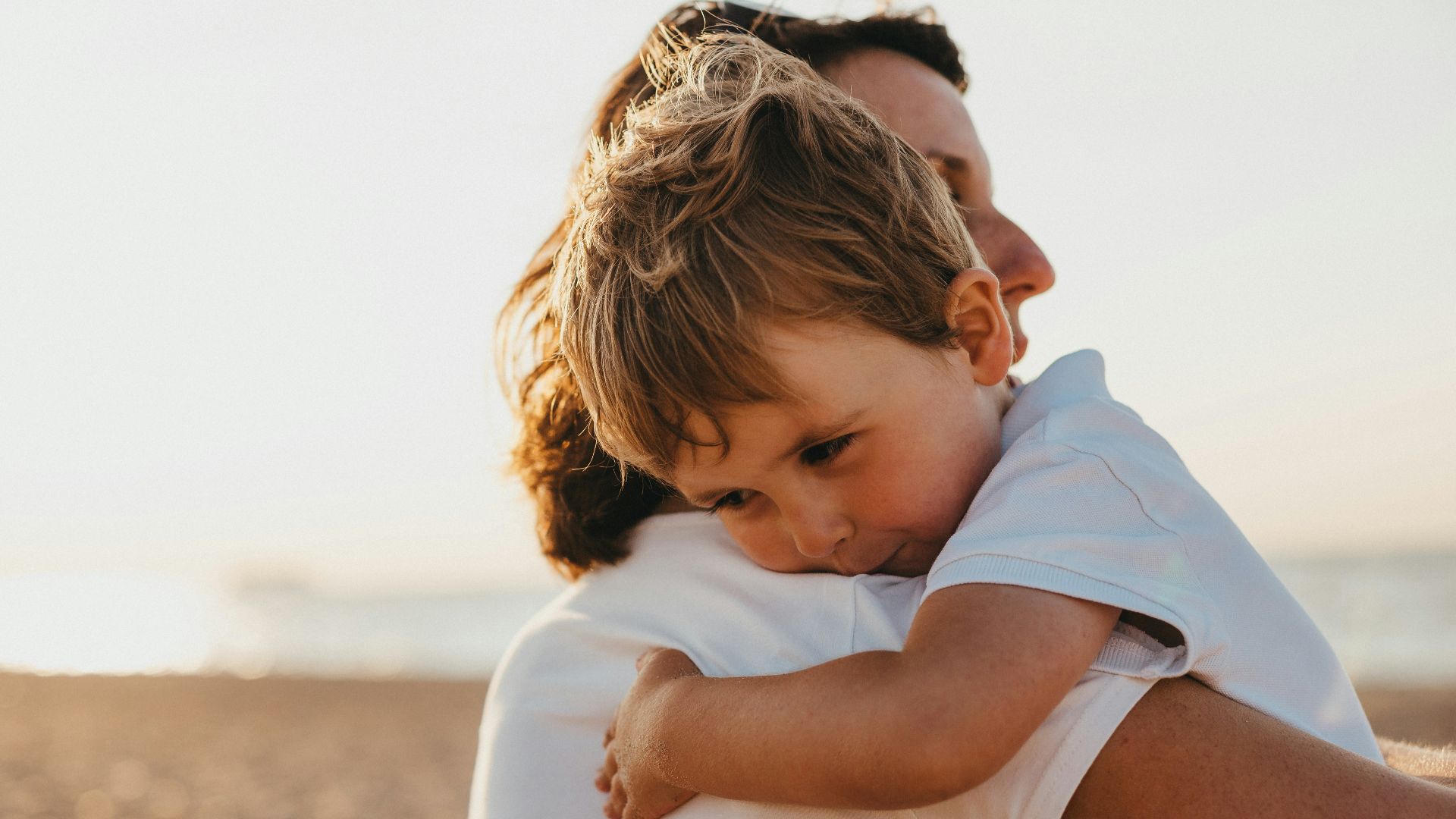 boy hugging woman during daytime