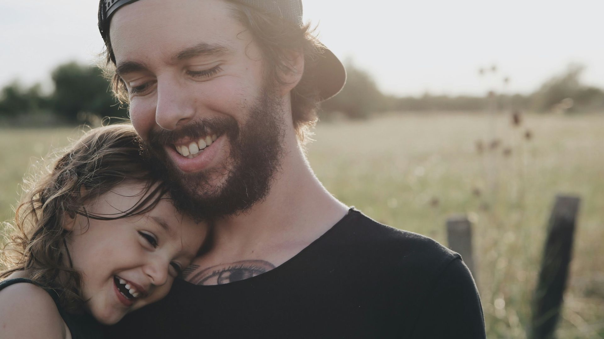 man carrying daughter in black sleeveless top