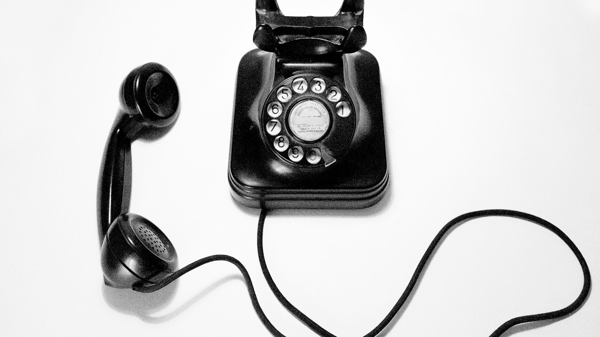 black rotary dial phone on white surface