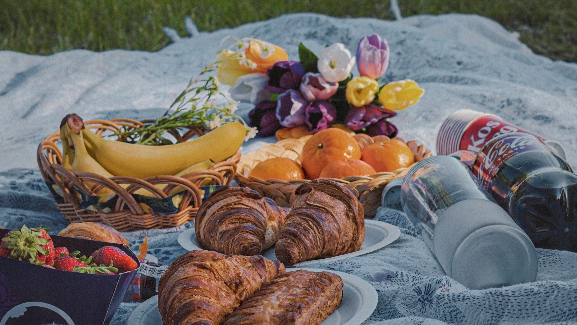 a picnic blanket with food and drinks on it