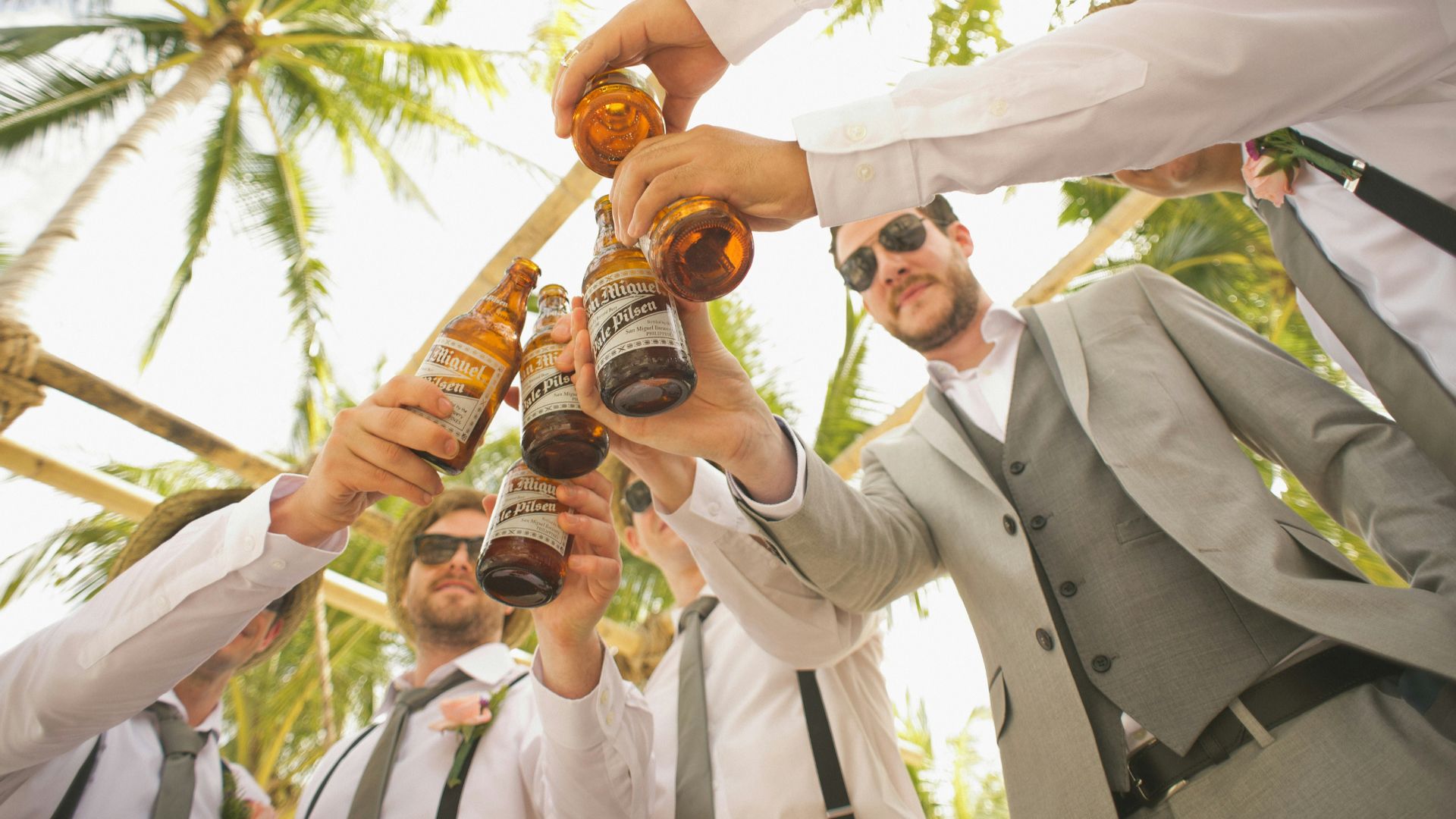 low angle of men holding beer bottles and having a toast