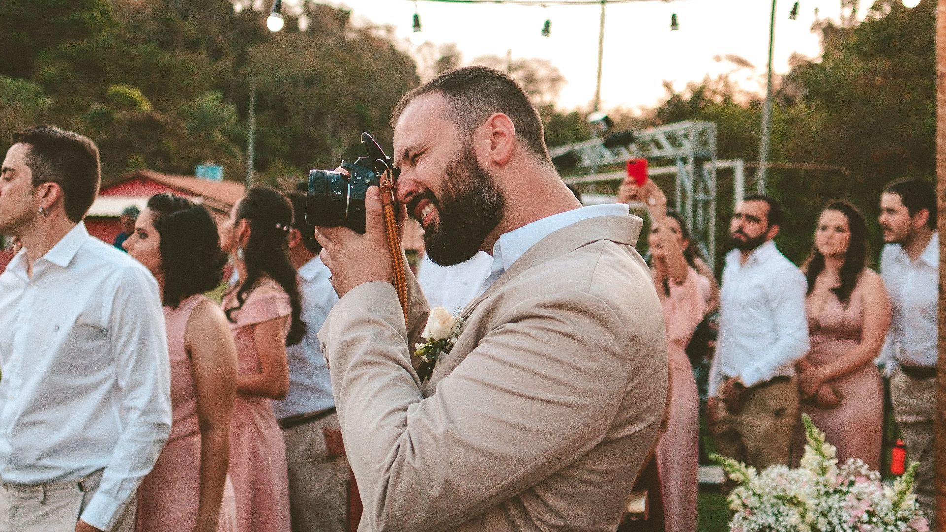 man taking photo using a black camera near a people in a line