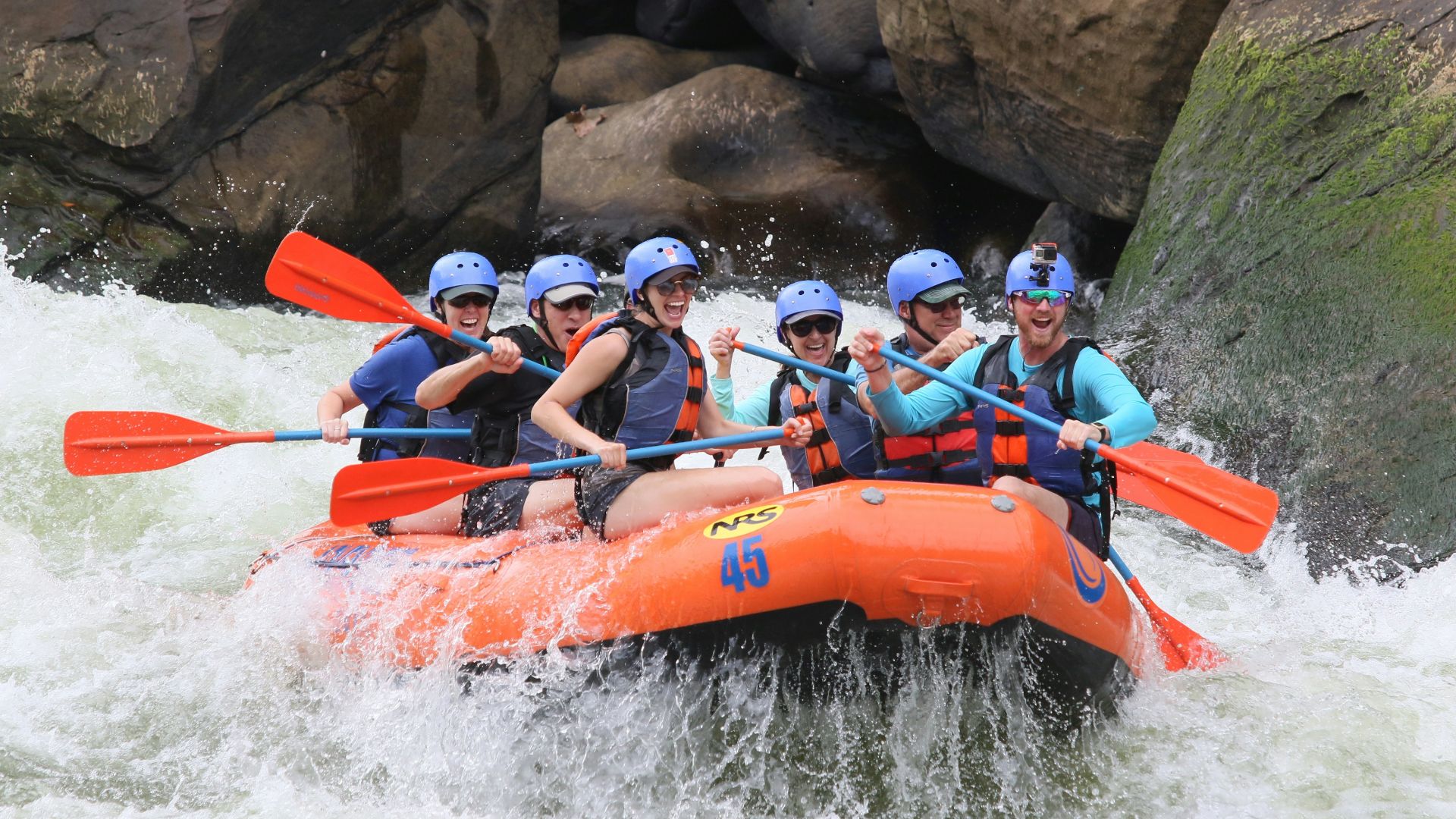 people riding orange kayak on river during daytime