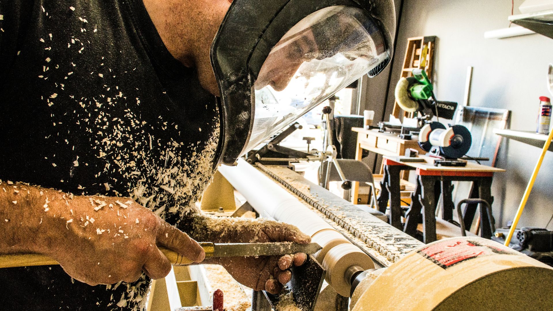 man wearing welding helmet in front of industrial machine