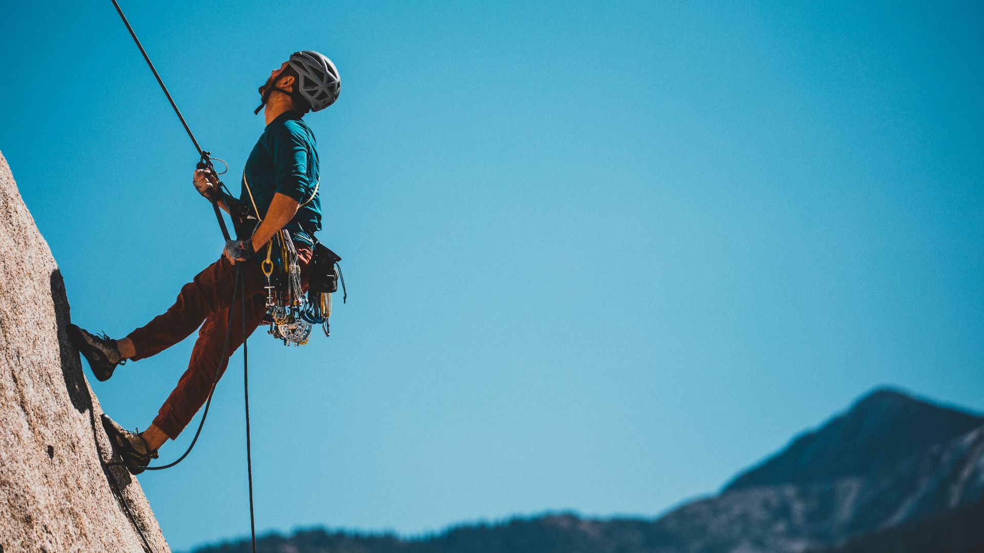man in blue and orange jacket and black helmet riding on black and white ski lift