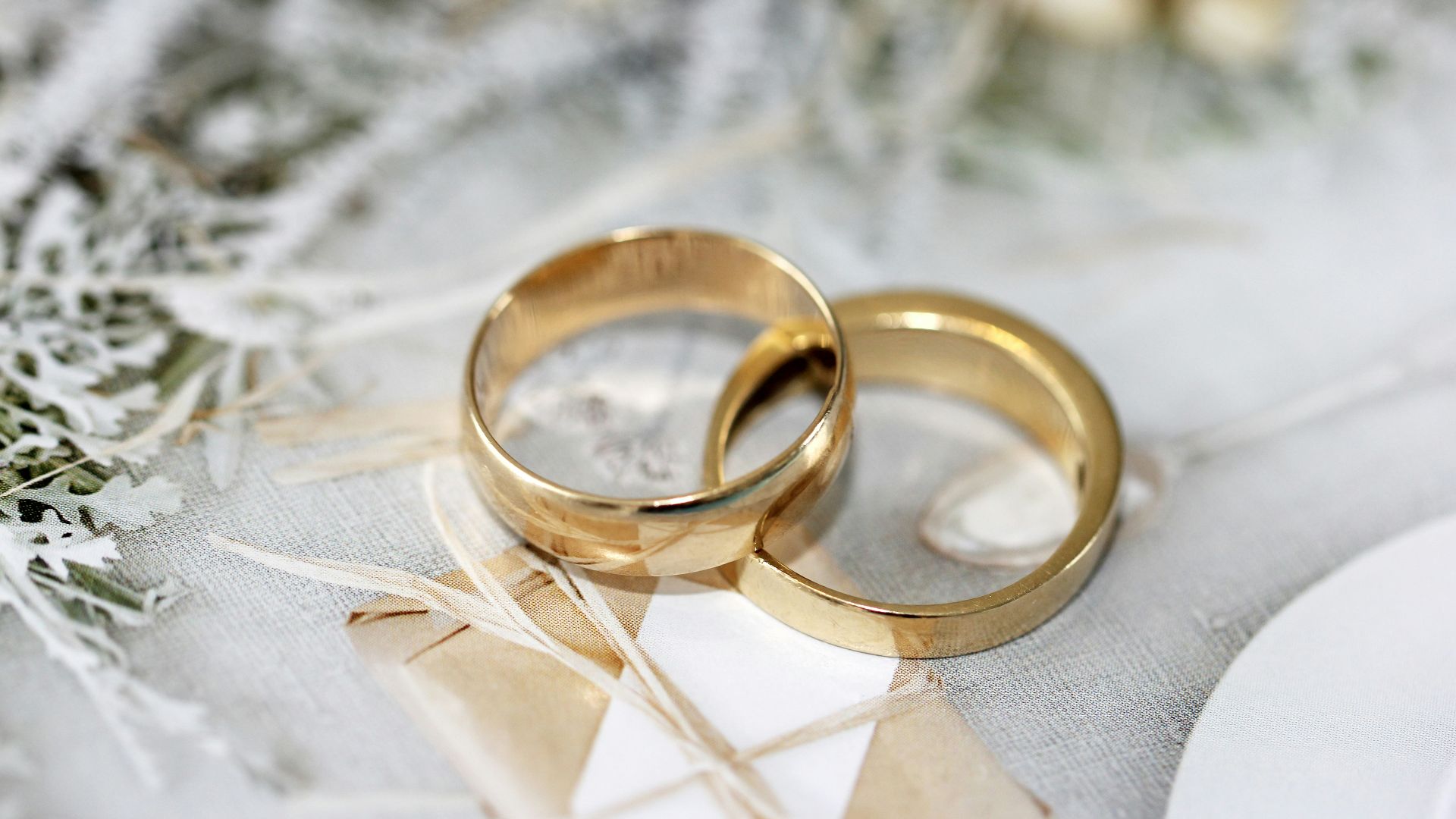 gold wedding band on white textile