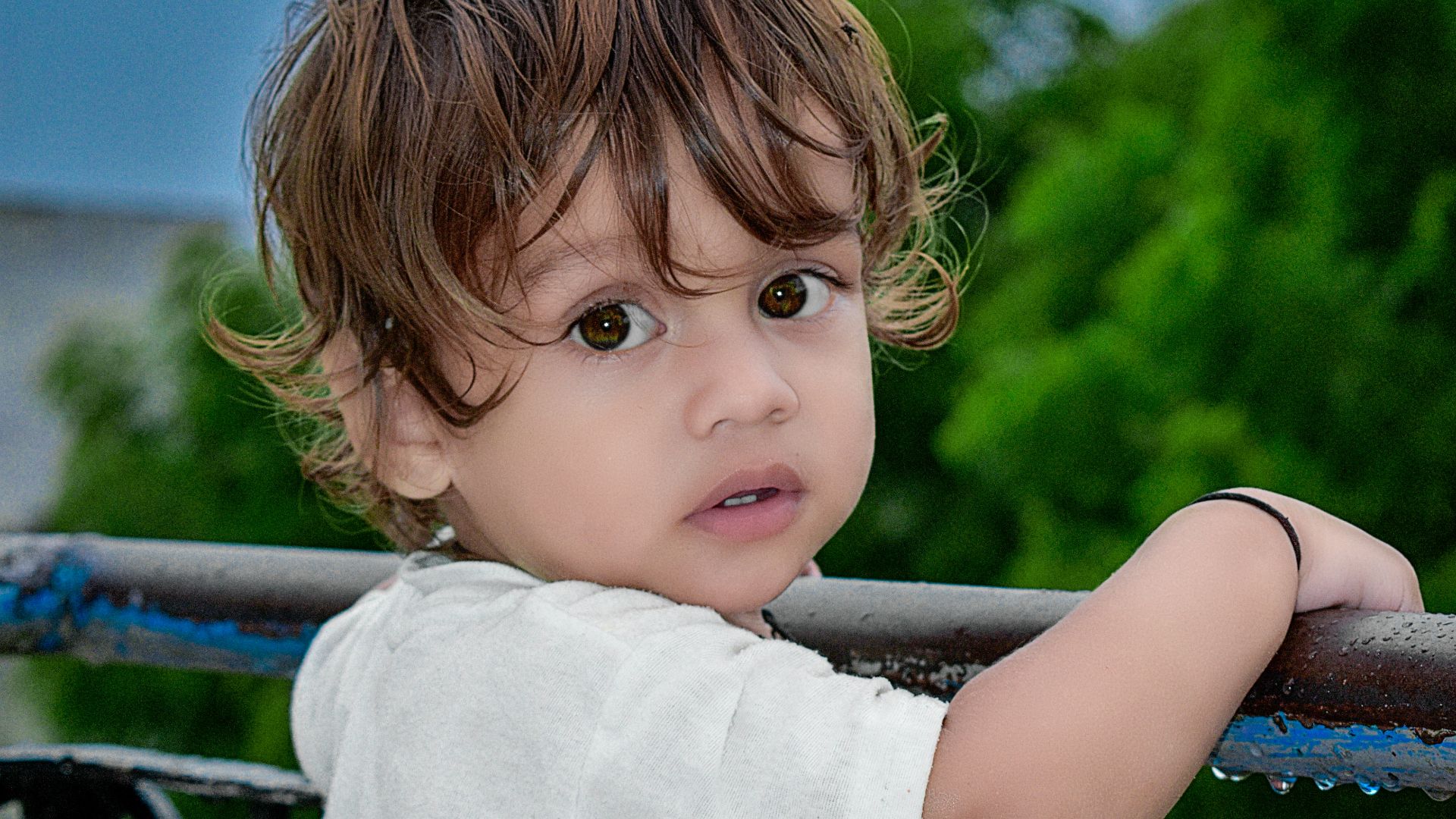 girl in white shirt standing on black metal railings during daytime