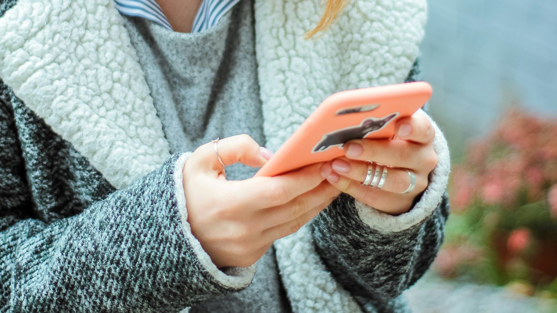 woman smiling while using her phone